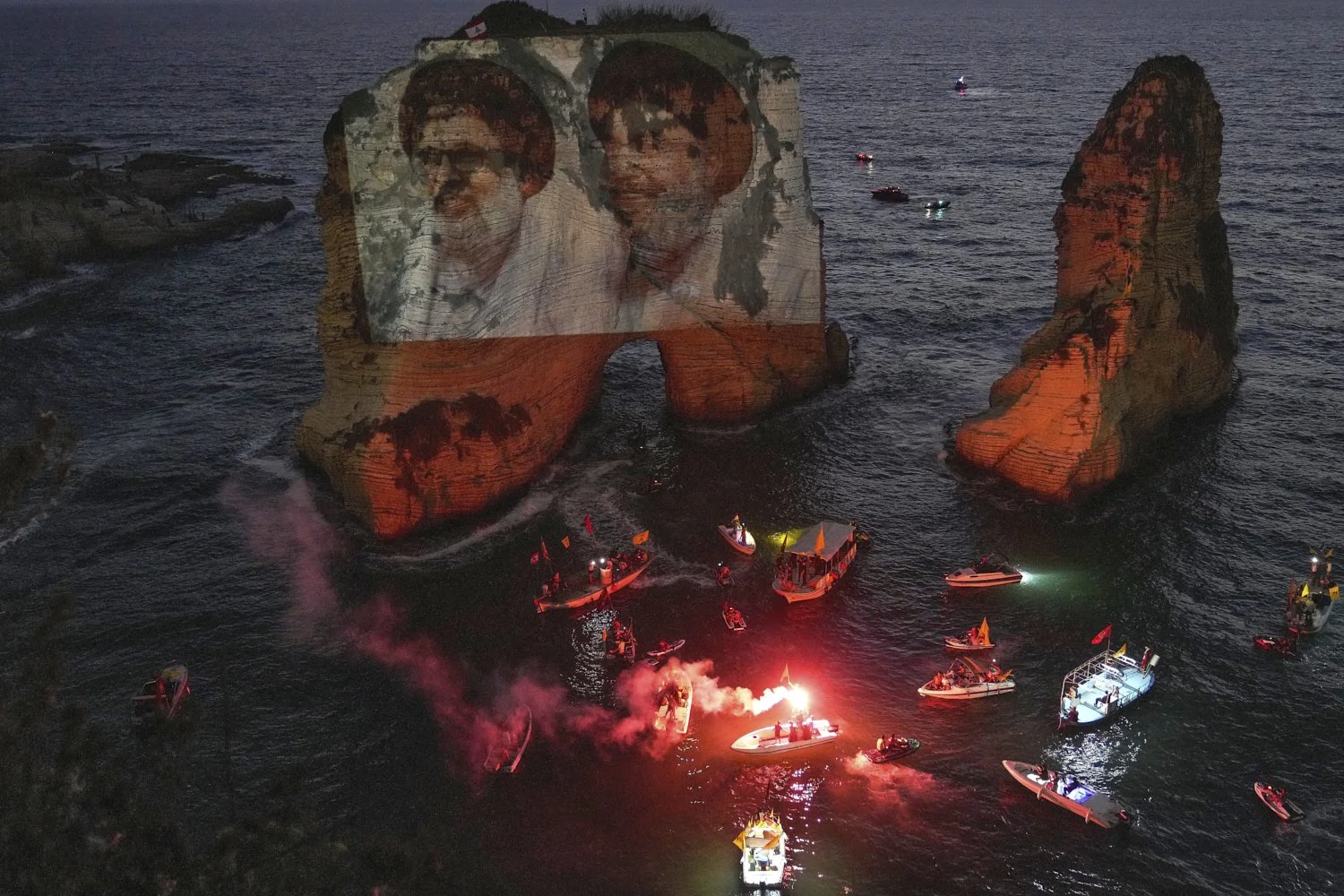 Portraits of two former Hezbollah leaders Hassan Nasrallah, right and Hashem Safieddine, left, are projected onto the landmark Raouche sea rock during an event commemorating their deaths in Israeli airstrikes nearly a year ago, in Beirut, Lebanon, T