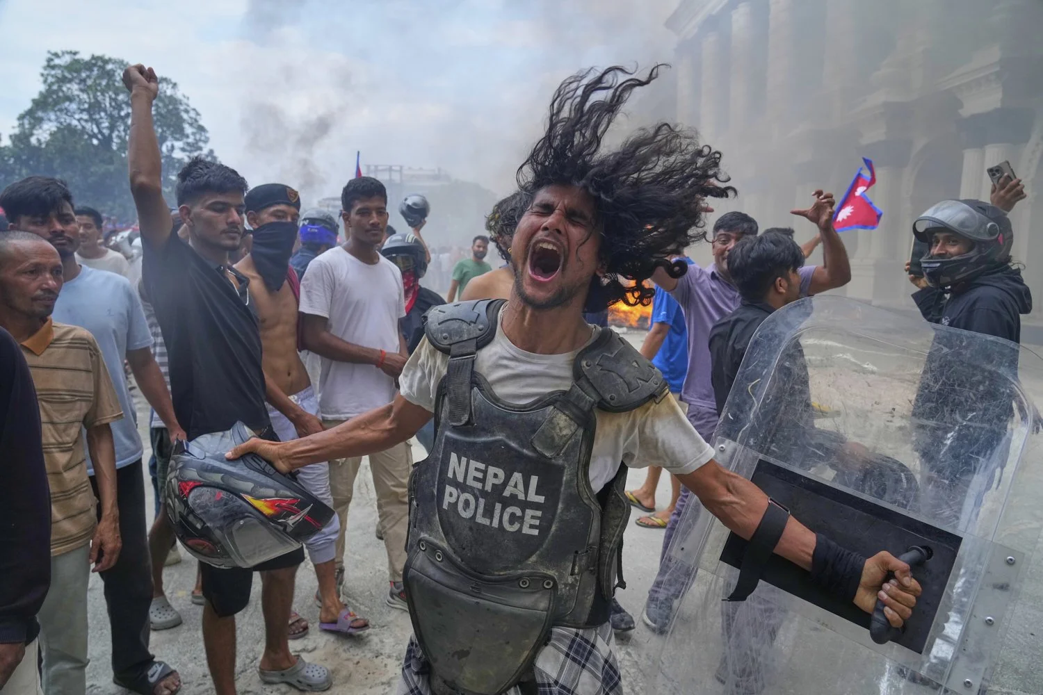 A protester wearing flak jacket and carrying a shield snatched from a policeman shouts slogans at the Singha Durbar, the seat of Nepal's government's various ministries and offices during a protest against social media ban and corruption in Kathmand