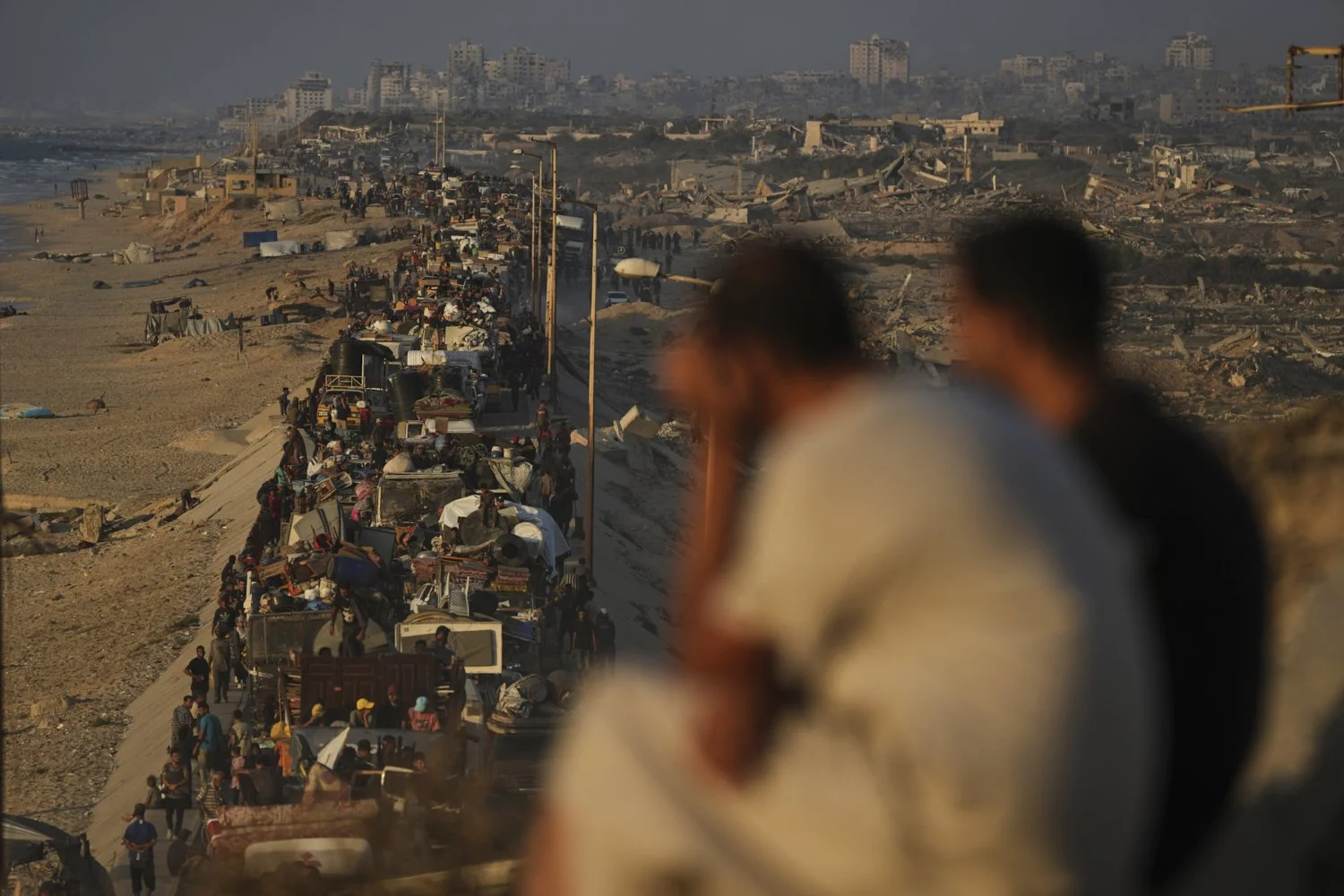 Displaced Palestinians flee northern Gaza by foot and in vehicles, carrying their belongings along the coastal road toward southern Gaza, Monday, Sept. 15, 2025. (AP Photo/Abdel Kareem Hana)