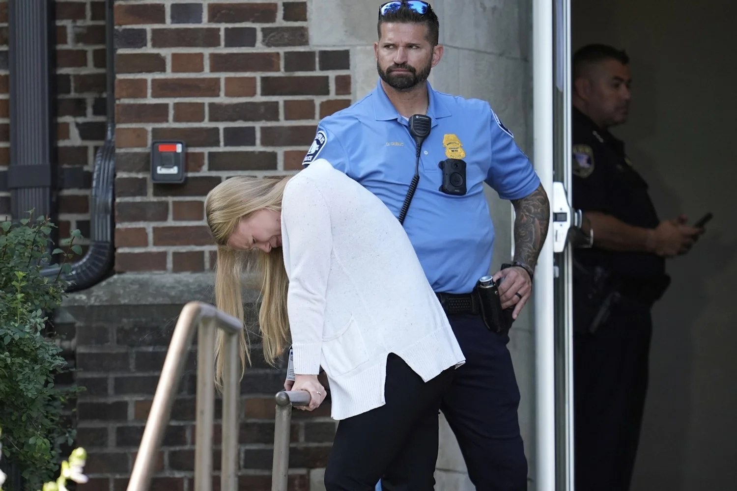 A woman pauses as she leaves the Annunciation Church's school as police respond to a reported mass shooting in Minneapolis, Minnesota, Aug. 27, 2025. (AP Photo/Abbie Parr)