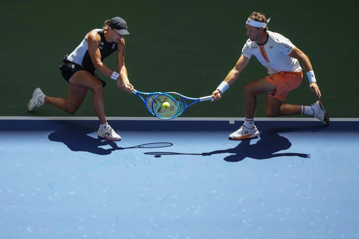 Norway's Casper Ruud, right, plays a shot as partner, Poland's Iga Swiatek, covers during their mixed doubles match at the U.S. Open tennis championships in New York, Aug. 19, 2025. (AP Photo/Yuki Iwamura)