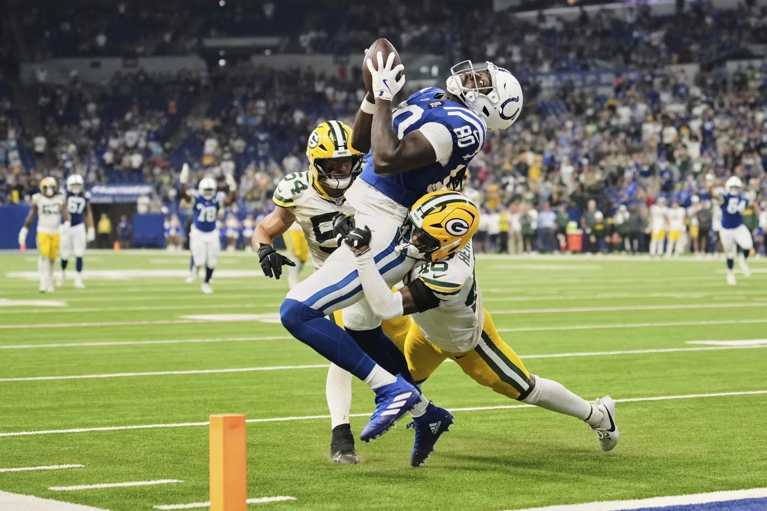 Indianapolis Colts tight end Jelani Woods (80) tries to make a catch while being hit by Green Bay Packers cornerback Tyron Herring (46) during a preseason NFL football game in Indianapolis, Indiana, Aug. 16, 2025. (AP Photo/AJ Mast)