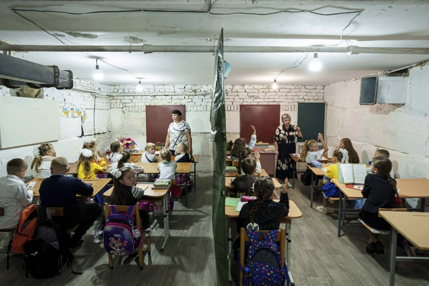 School students listen to their teachers during a lesson, in the basement of a municipal building during the first day in school in Bobryk, Sumy region, Ukraine, Monday, Sept. 1, 2025. The Bobryk school was forced to move to the basement due to endl