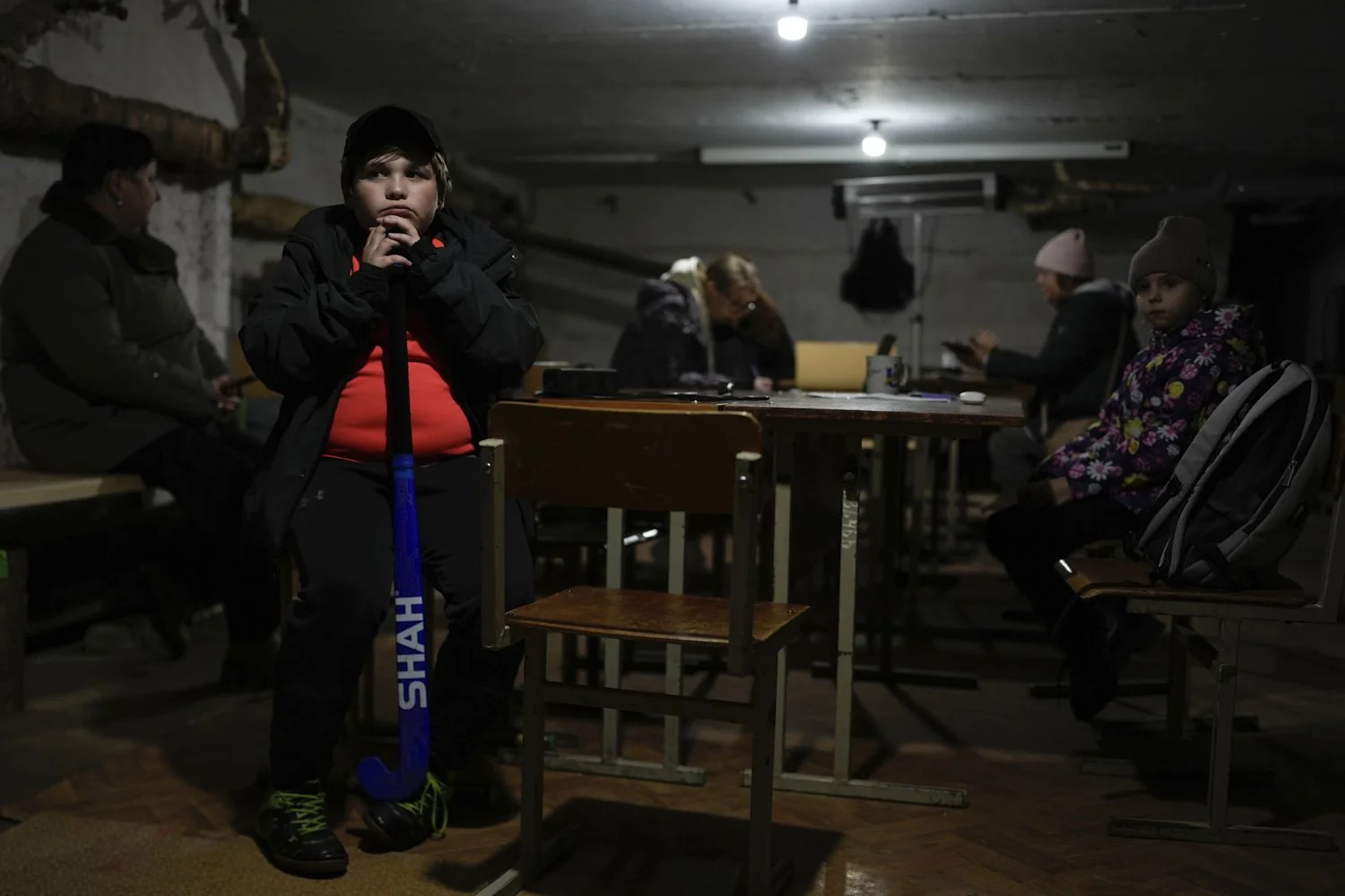  Tymofii Lifyrynko, 11, holds his hockey stick while waiting out an air raid alarm in an underground shelter in Shostka, Ukraine, Oct. 16, 2025. (AP Photo/Julia Demaree Nikhinson) 