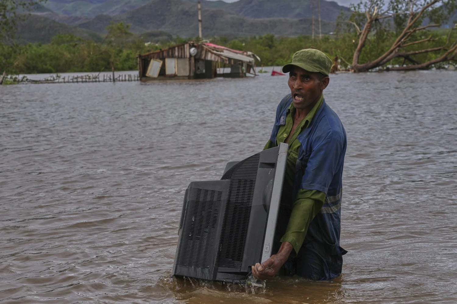  A man wades through a flooded area carrying a TV from his home in the aftermath of Hurricane Melissa, in Santiago de Cuba, Oct. 29, 2025. (AP Photo/Ramon Espinosa) 