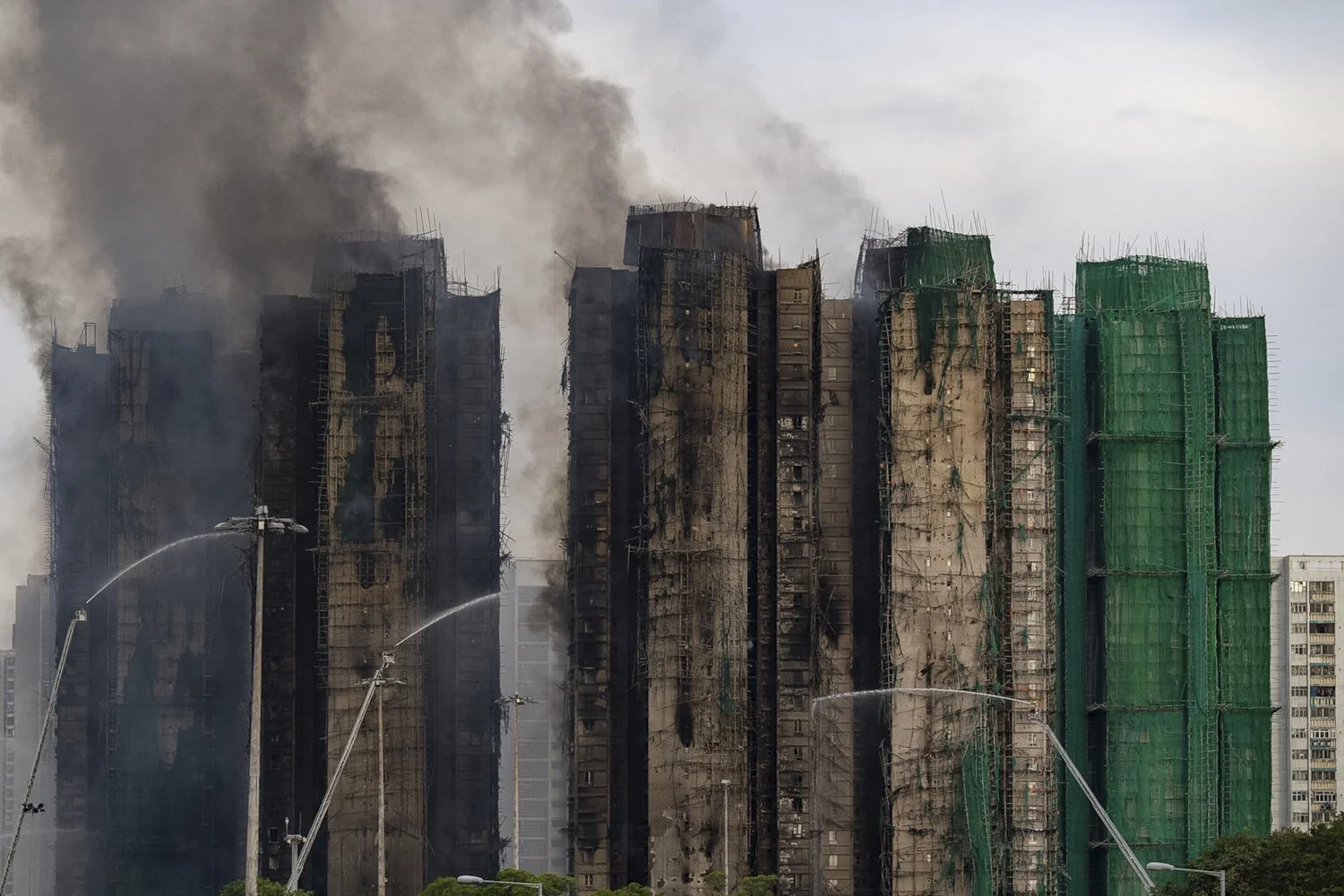  Firefighters work to extinguish a fire which broke out Wednesday at Wang Fuk Court, a residential estate in the Tai Po district of Hong Kong's New Territories, Thursday, Nov. 27, 2025. (AP Photo/Chan Long Hei) 