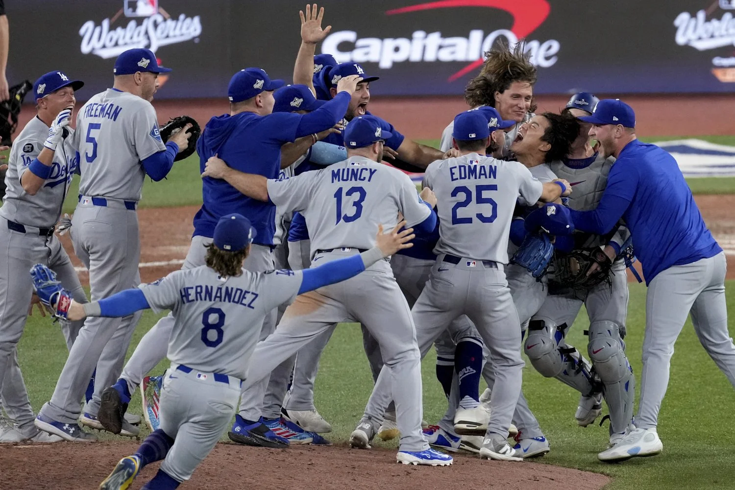 The Los Angeles Dodgers surround pitcher Yoshinobu Yamamoto as they celebrate their win in Game 7 of baseball's World Series against the Toronto Blue Jays, Sunday, Nov. 2, 2025, in Toronto. (AP Photo/Ashley Landis) 