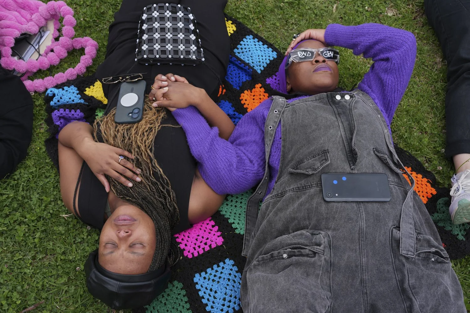  Participants hold hands as they lie on the ground during a gender-based violence protest at the forecourt of the botanical gardens in Johannesburg, South Africa, Friday, Nov. 21, 2025. (Misper Apawu) 