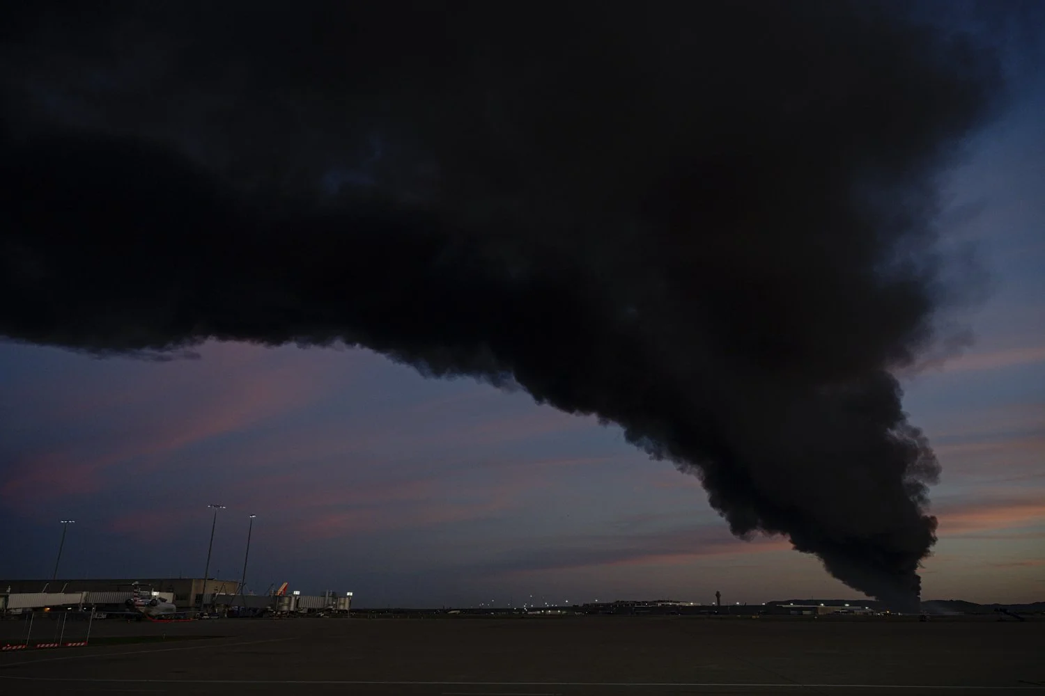  A plume of smoke wafts over airport property after reports of a plane crash at Louisville International Airport, Tuesday, Nov. 4, 2025, in Louisville, Ky. (AP Photo/Jon Cherry) 