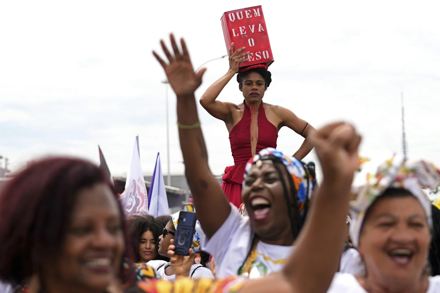  A woman balances a container on her head with a message that reads in Portuguese: "Who carries the weight", during the National Black Women's March marking the historic 2015 mobilization that became a landmark moment in the fight for racial and gend