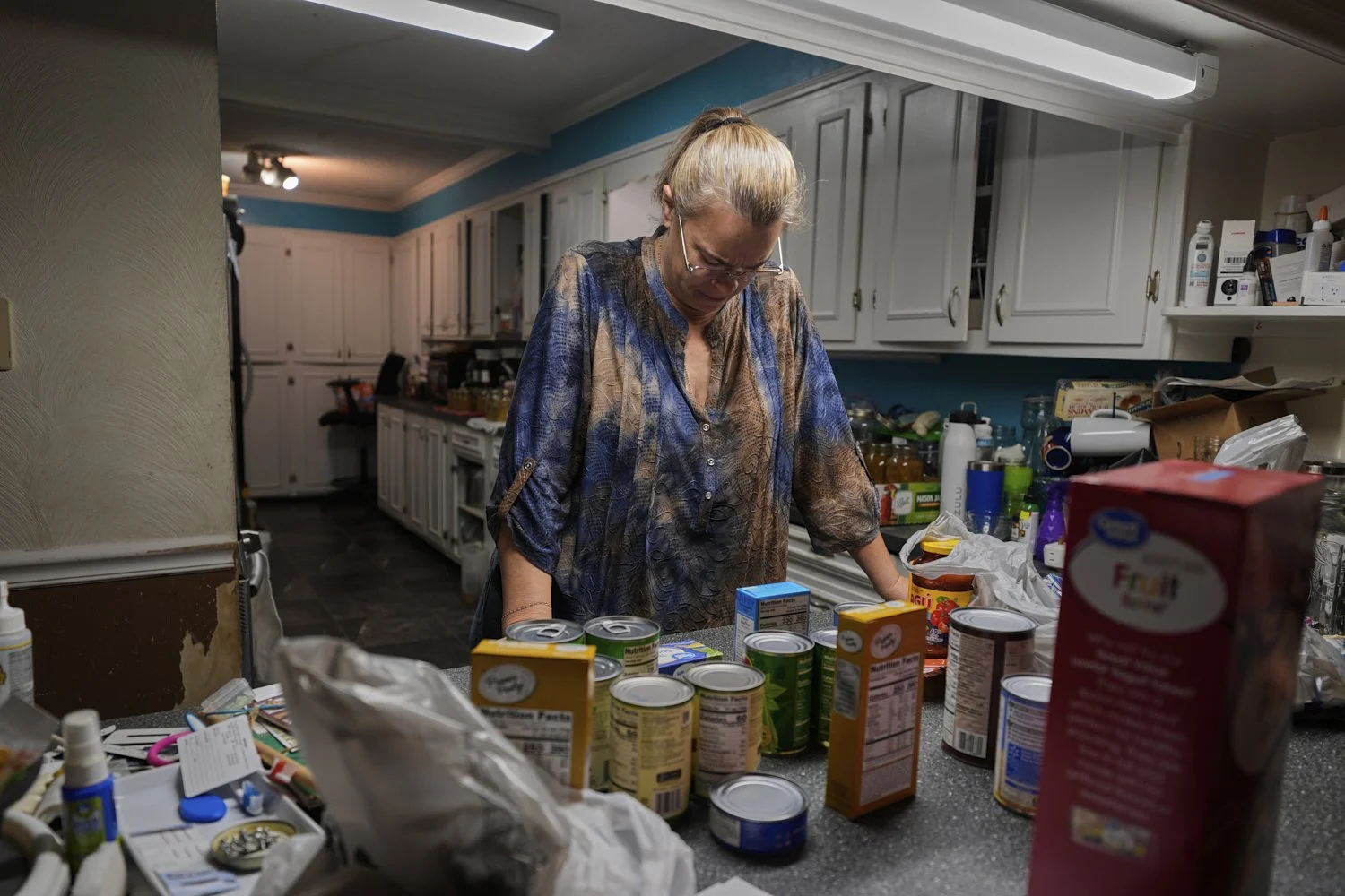  Goldie Getter, the wife of a civil service employee who was furloughed due to the government shutdown, unpacks groceries her husband received from a food bank, in Gulfport, Miss., Monday, Nov. 3, 2025. (AP Photo/Gerald Herbert) 