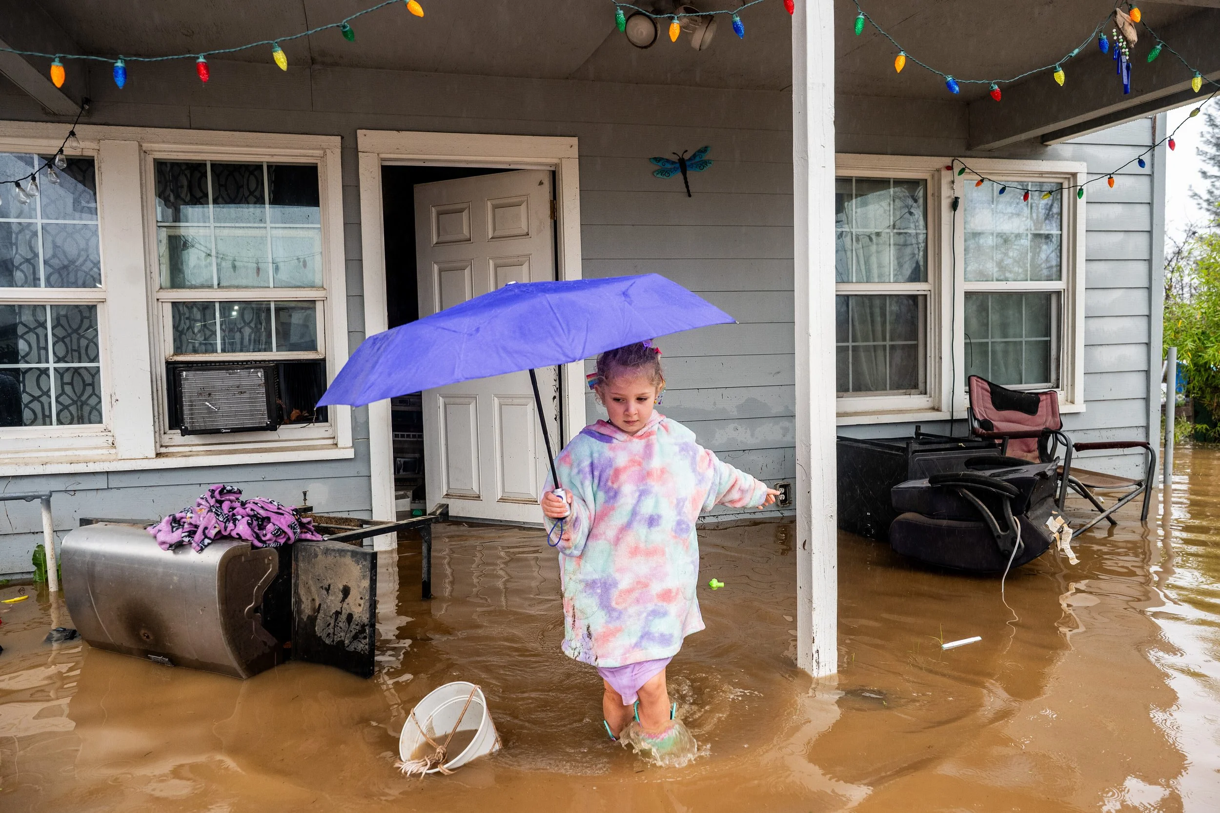  Aria Wogoman leaves her flooded home in Redding, California, following heavy rain, Dec. 22, 2025. (AP Photo/Noah Berger) 