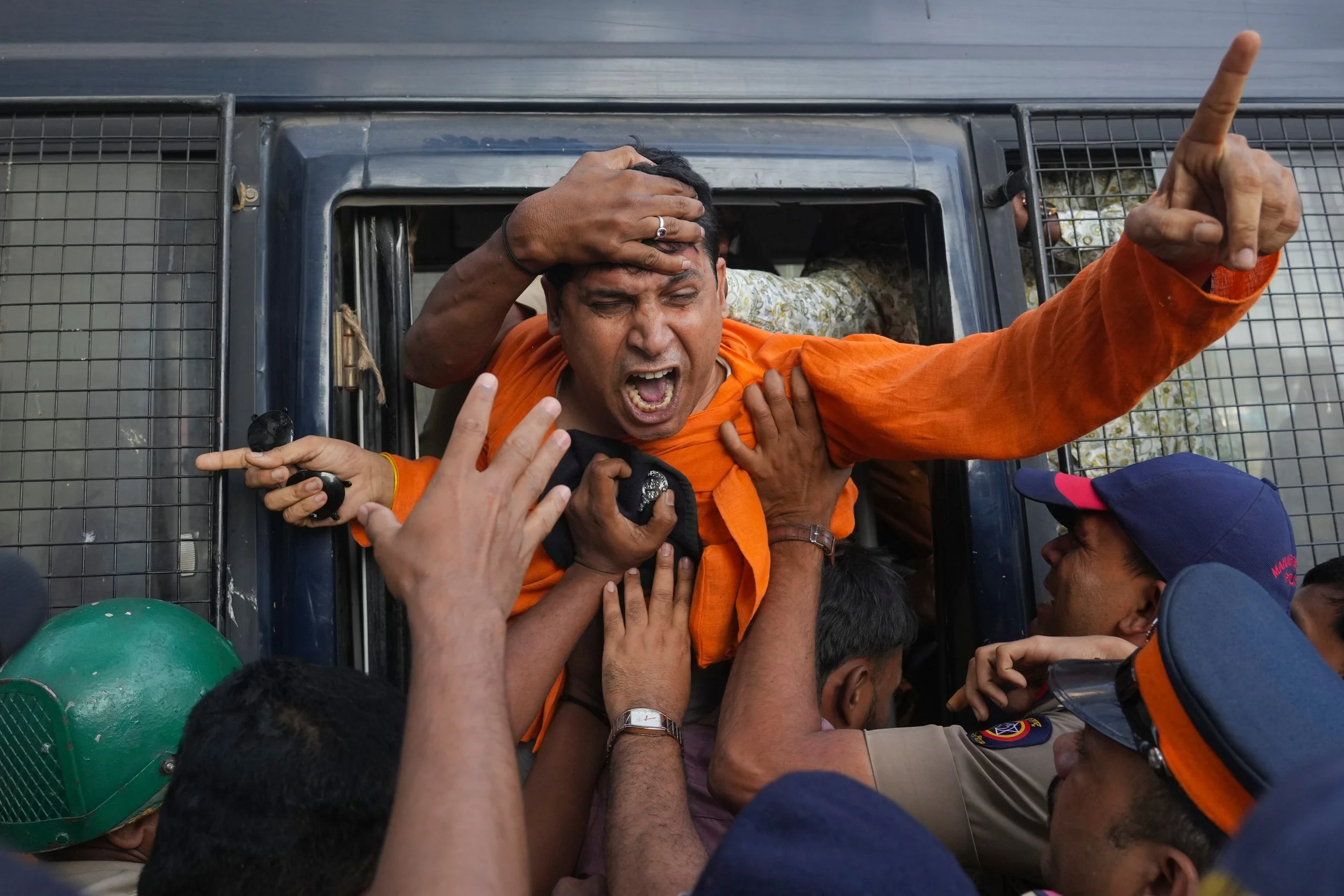  An activist from the Vishwa Hindu Parishad, a right-wing Hindu nationalist organization, shouts slogans as police detain him during a protest near the Deputy High Commission of Bangladesh, alleging that Bangladeshi groups are wrongly targeting India