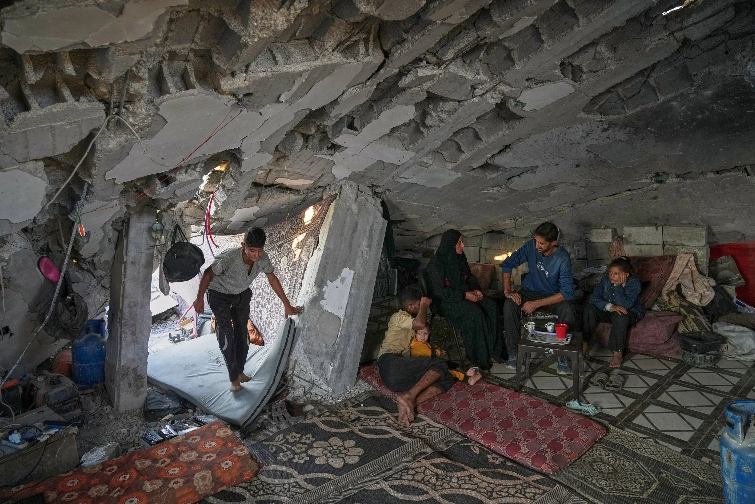 Sahar Taroush speaks with her brother after returning to her collapsed home in Jabaliya, Gaza City, Nov. 11, 2025, following the latest ceasefire. Her children are Ammar, far left, Hassan sitting with with his 2-year-old sister Ahlam, and Bisan, rig