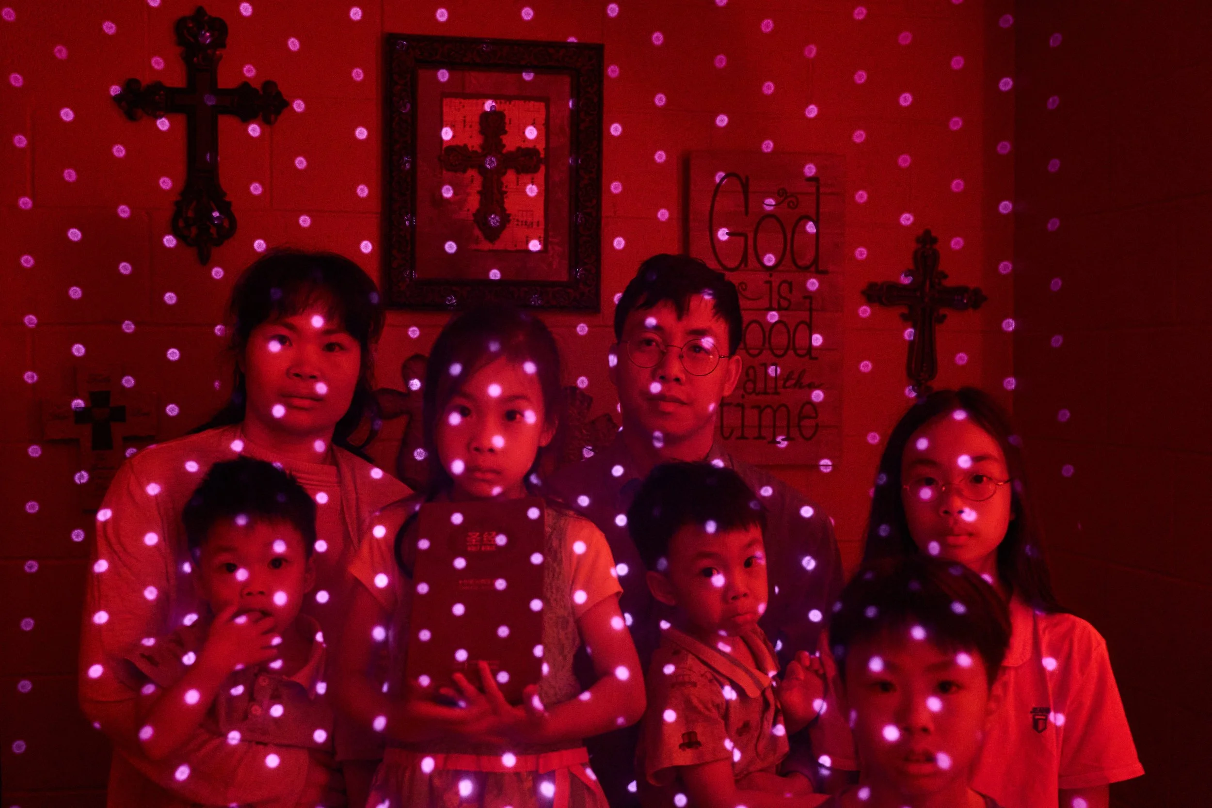  Members of a Chinese church living in exile after fleeing from China, are illuminated by beams of pulsed laser light from a cellphone's LiDAR scanner as they sit for a photo, Oct. 12, 2025, in Midland, Texas. Photographed are Wensheng Wen, rear righ