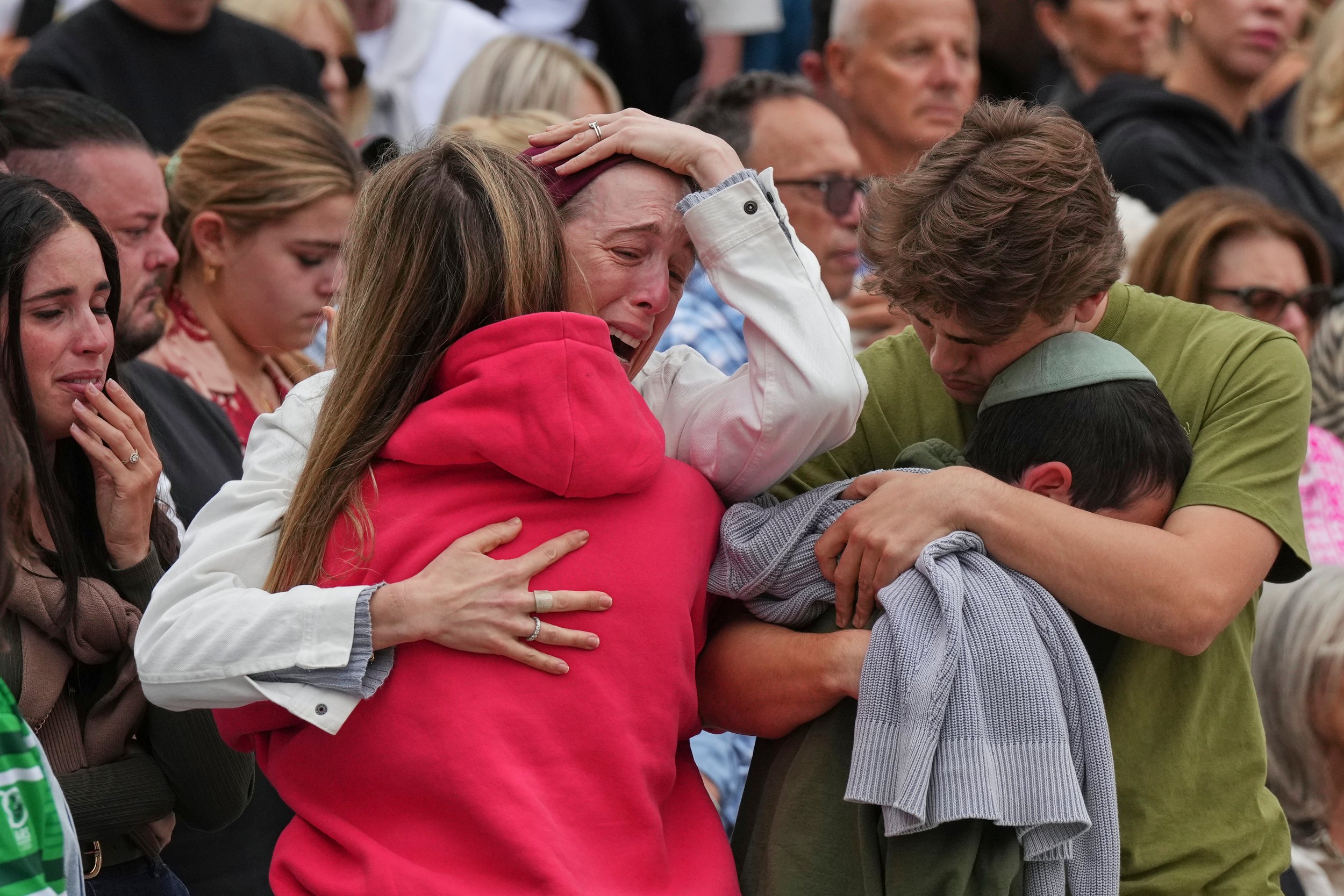  A family mourns during a menorah lighting ceremony for the victims of a shooting on Bondi Beach, in Sydney, Australia, Tuesday, Dec. 16, 2025. (AP Photo/Mark Baker) 