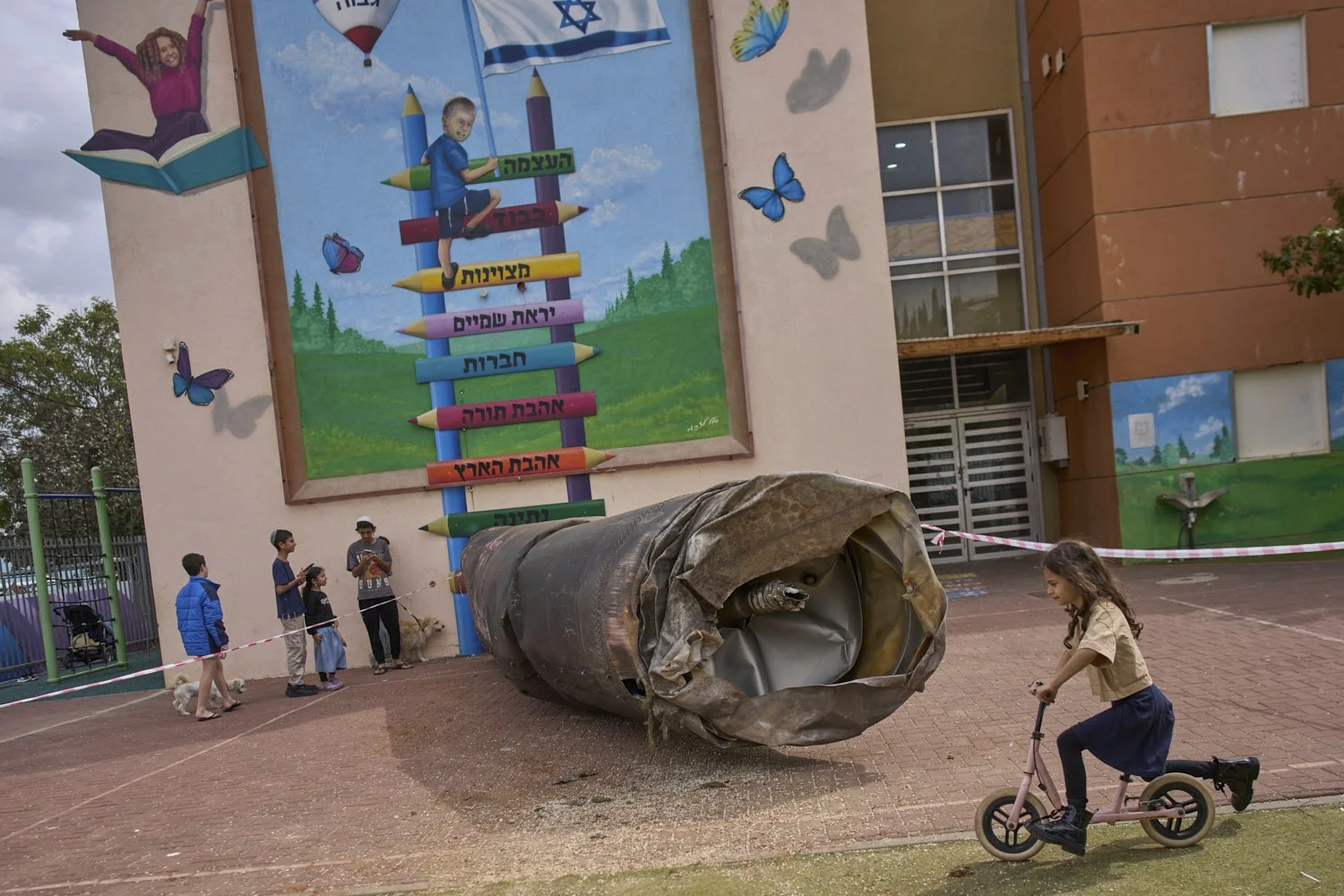 Children play beside a fragment of an Iranian ballistic missile that landed in a schoolyard in the Israeli settlement of Peduel in the West Bank, March 23, 2026. (AP Photo/Ohad Zwigenberg) 