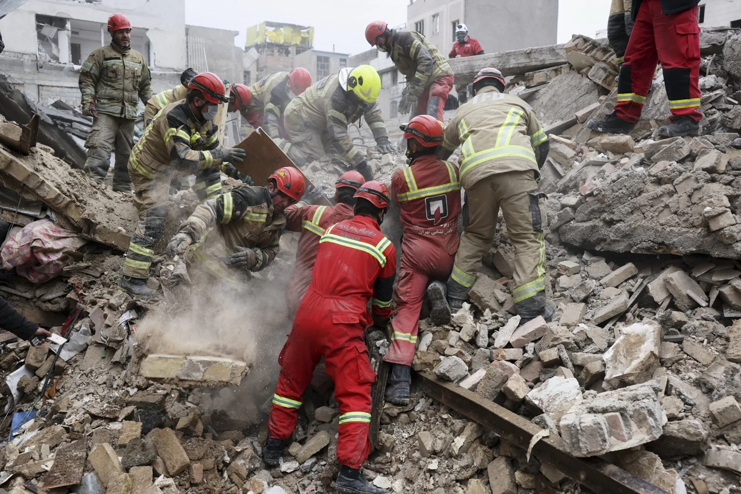   Rescue workers search for survivors in the rubble after a strike in southern Tehran, Iran, March 13, 2026. (AP Photo/Sajjad Safari) 