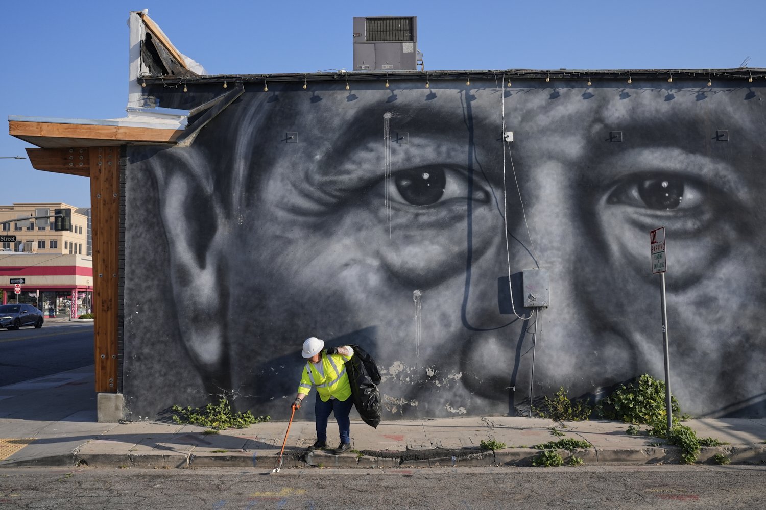  A sanitation worker picks up trash next to a mural of César Chavez in Bakersfield, Calif., March 19, 2026. (AP Photo/Godofredo A. Vásquez) 
