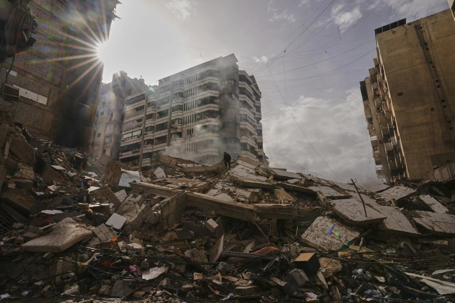  A man stands atop the rubble as smoke rises from a building destroyed in an Israeli airstrike in Dahiyeh, Beirut's southern suburbs, Lebanon, March 14, 2026. (AP Photo/Hassan Ammar) 