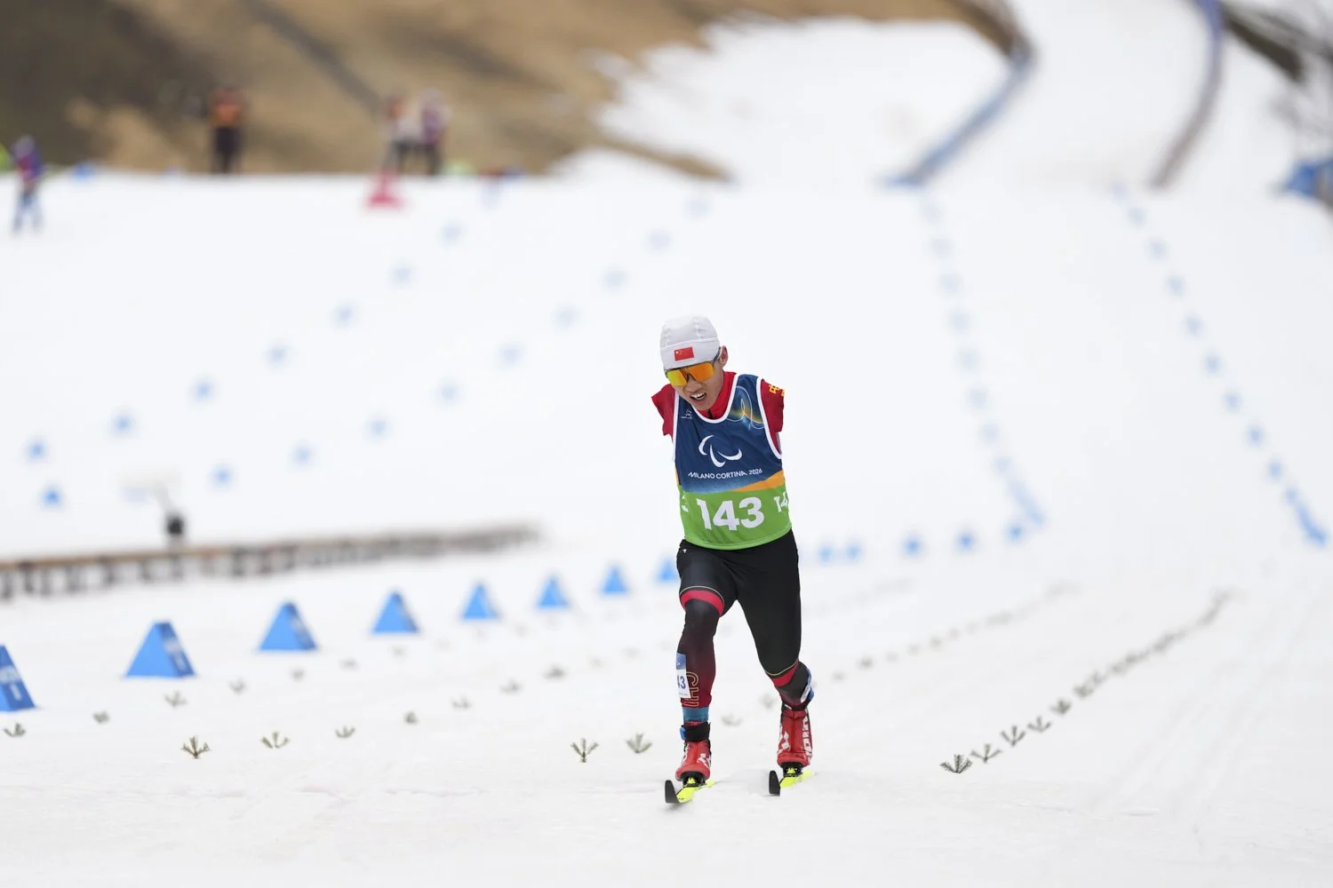  Wang Chenyang, of China, crosses the finish line in the cross-country skiing men's 10Km interval start classic standing final at the 2026 Winter Paralympics, in Tesero, Italy, March 11, 2026. (AP Photo/Evgeniy Maloletka) 