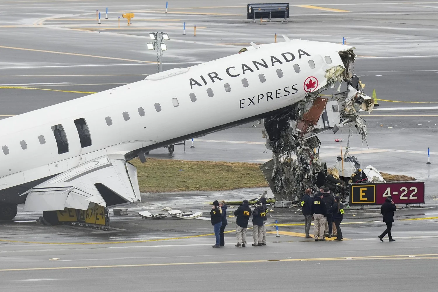 Officials with the National Transportation Safety Board investigate the site on March 23, 2026, where an Air Canada jet came to rest after colliding with a Port Authority firetruck at LaGuardia Airport, shortly after landing in New York. (AP Photo/S