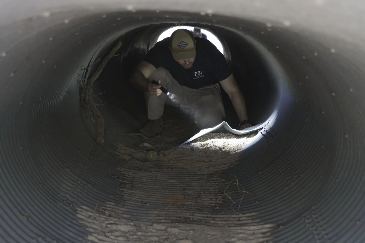  An investigator searches inside a culvert in the neighborhood where Annie Guthrie, whose mother Nancy Guthrie has been missing for more than a week, lives outside Tucson, Ariz., Feb. 10, 2026. (AP Photo/Ty ONeil) 
