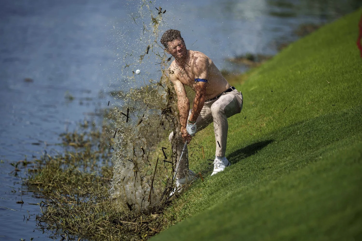  Michael Brennan sends mud and water flying as he tries to hit his ball out of floating debris on the 18th hole, only to have it land back in the water, during the first round of the PGA Zurich Classic golf tournament at TPC Louisiana, in Avondale, A