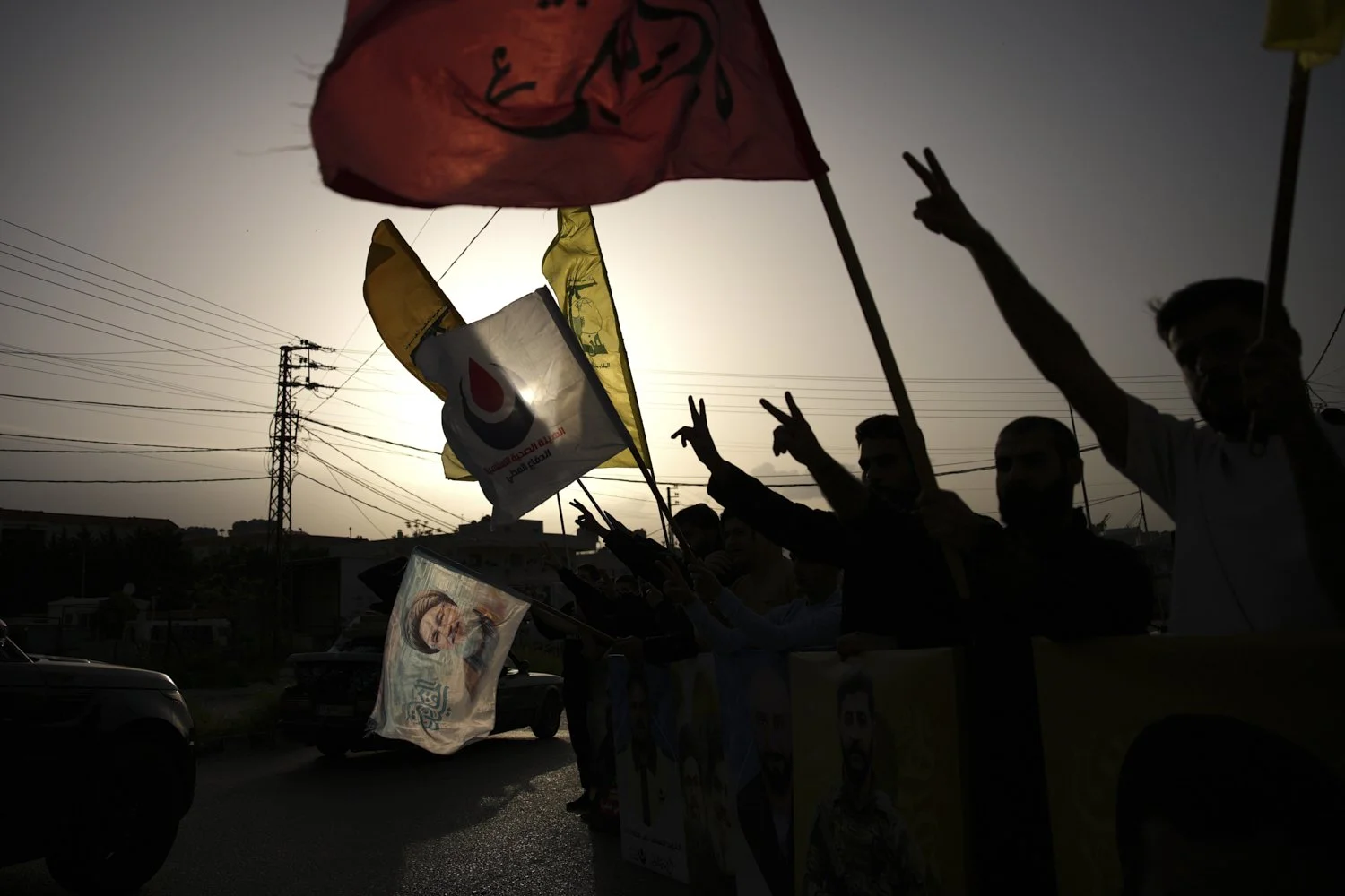  People wave Hezbollah flags and an image of late Hezbollah leader Hassan Nasrallah, in Zefta, Lebanon, April 17, 2026, as displaced residents drive back to their villages following a ceasefire between Israel and Hezbollah. (AP Photo/Hassan Ammar) 