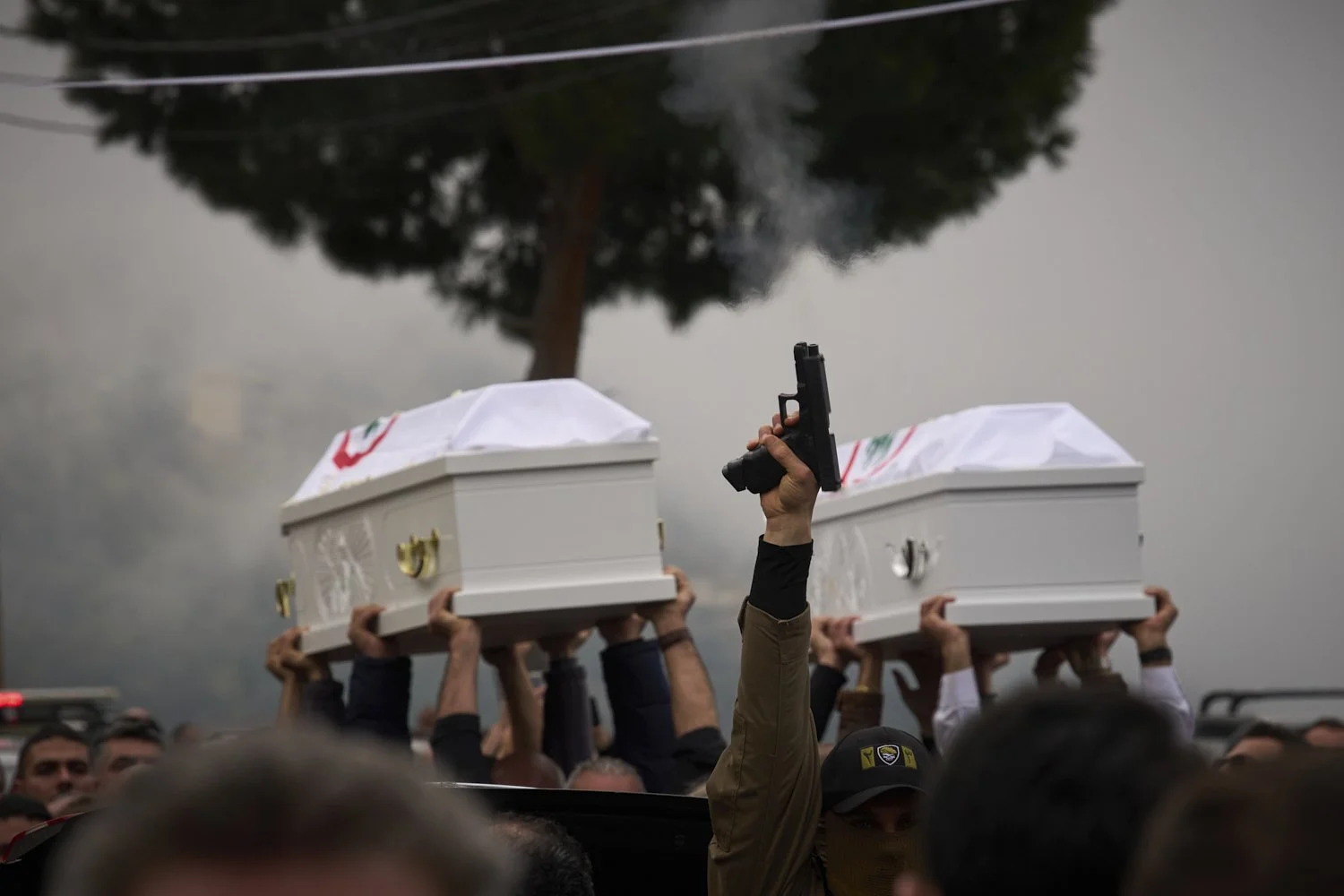  A gunman fires his gun as men carry the coffins with the remains of Pierre Mouawad, an official with the anti-Hezbollah Lebanese Forces party, and his wife, during their funeral in Yahshush, Lebanon, April 7, 2026. (AP Photo/Emilio Morenatti) 