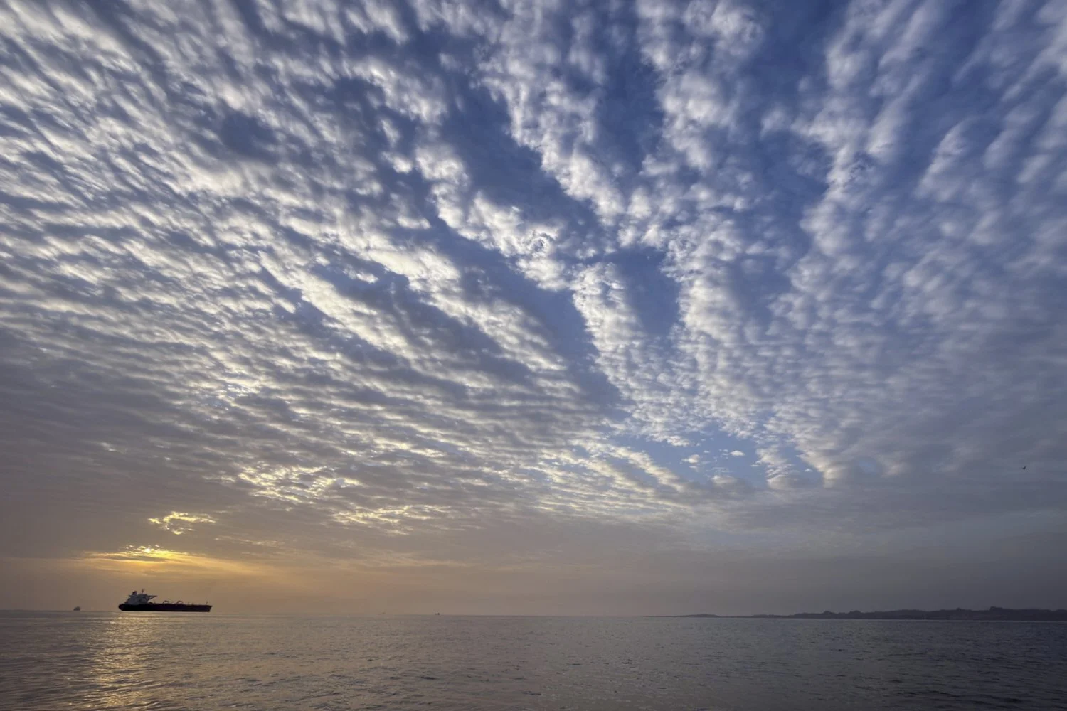  The sun rises behind a tanker anchored in the Strait of Hormuz off the coast of Qeshm Island, Iran, April 18, 2026. (AP Photo/Asghar Besharati) 