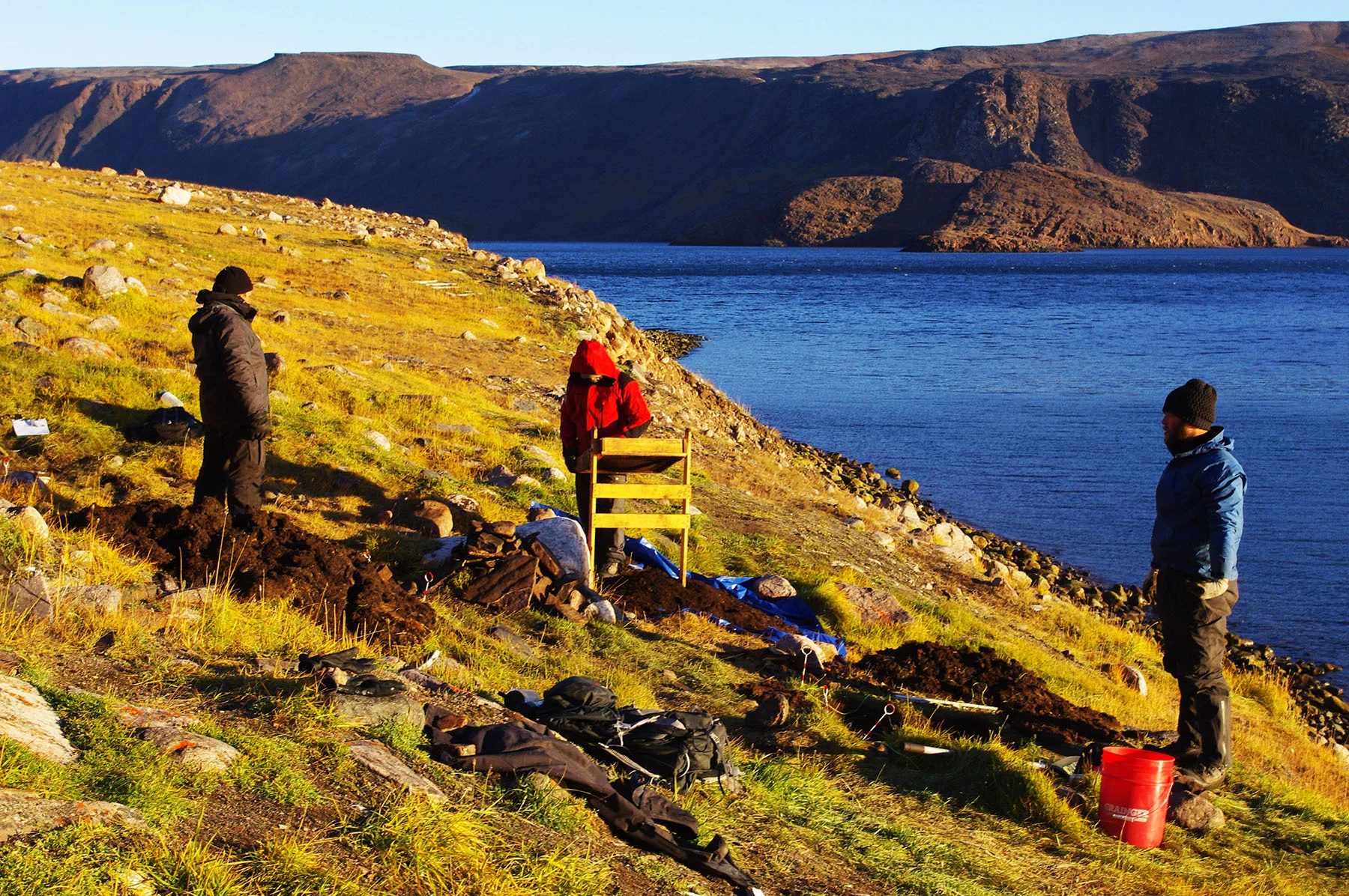 Researchers Hans Lennert, Hans Lange and Justin Junge excavate Late Dorset culture artifacts from Iita in Greenland. The site served as a crossroads for various paleo-Inuit cultures crossing into Greenland. Climate change is endangering its long-term viability, so archaeologists are racing against time to save what they can. Photo: John Darwent