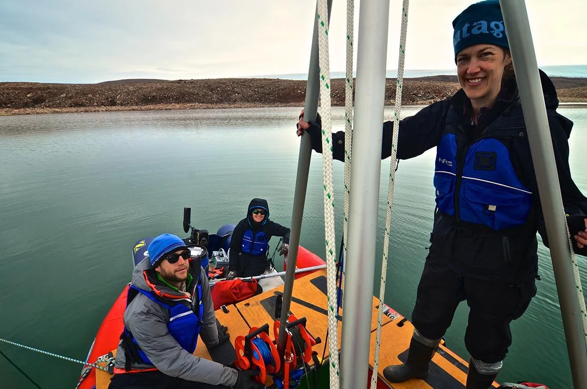 Researcher Yarrow Axford and Ph.D. students prepare to take a sediment core from a lake in northwest Greenland. Photo credit: Alex P. Taylor