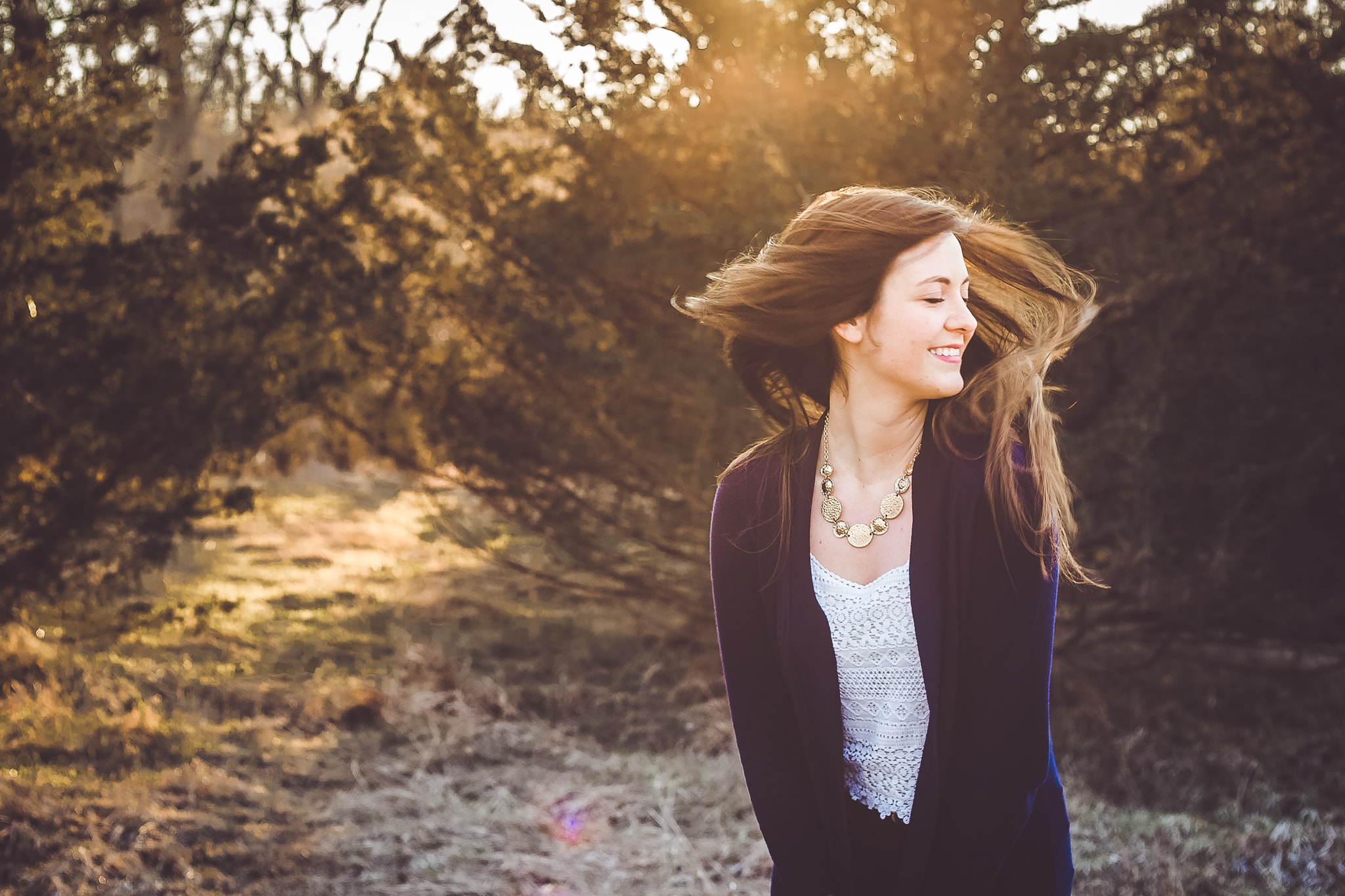 A beautiful, young senior girl turns her head and her long hair turns in the wind in this senior photograph by L+R Photography - Tulsa, OK