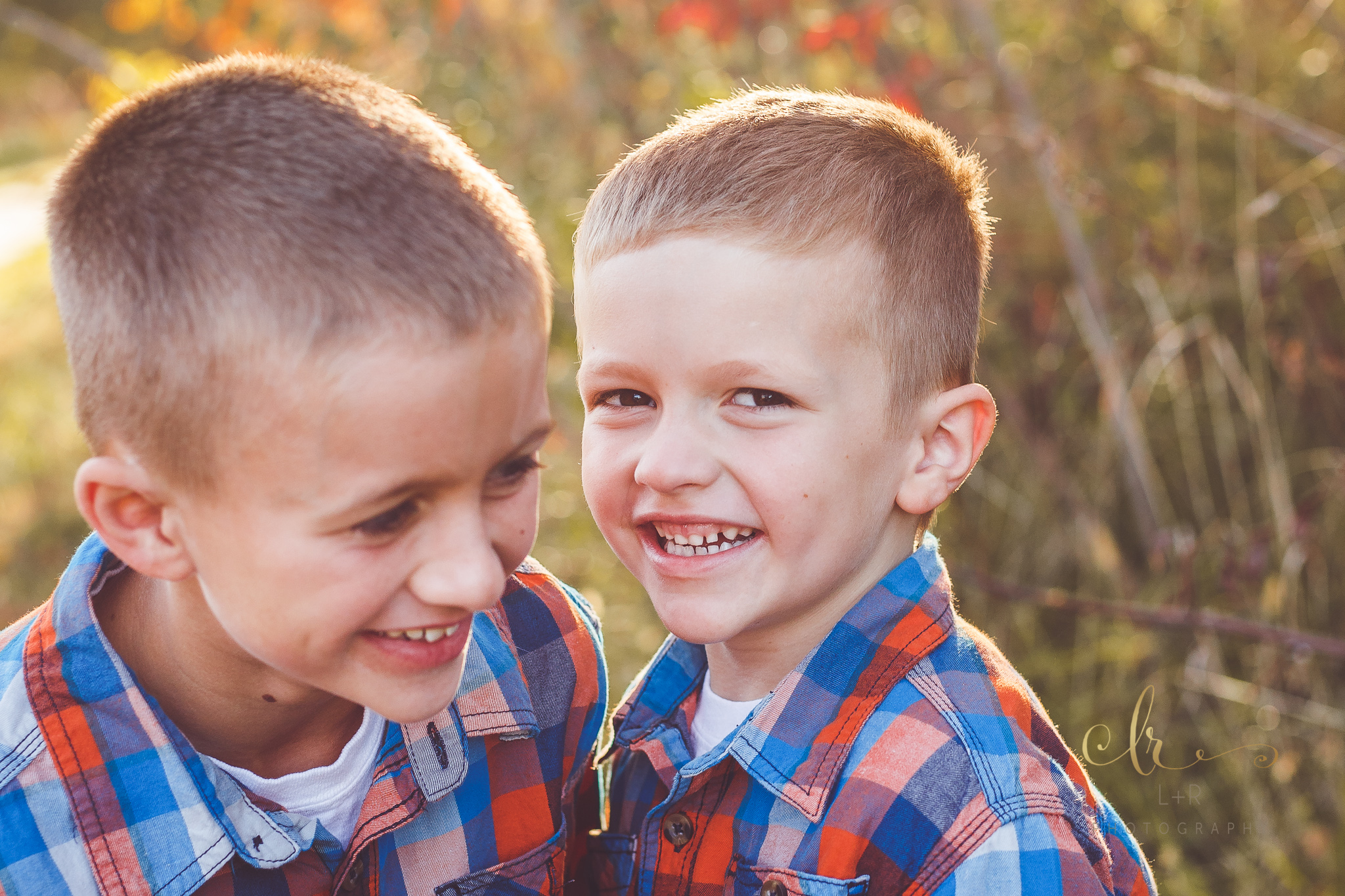 Two young brothers, share a laugh and smile during their family photography session by L&R Photography in Tulsa, OK