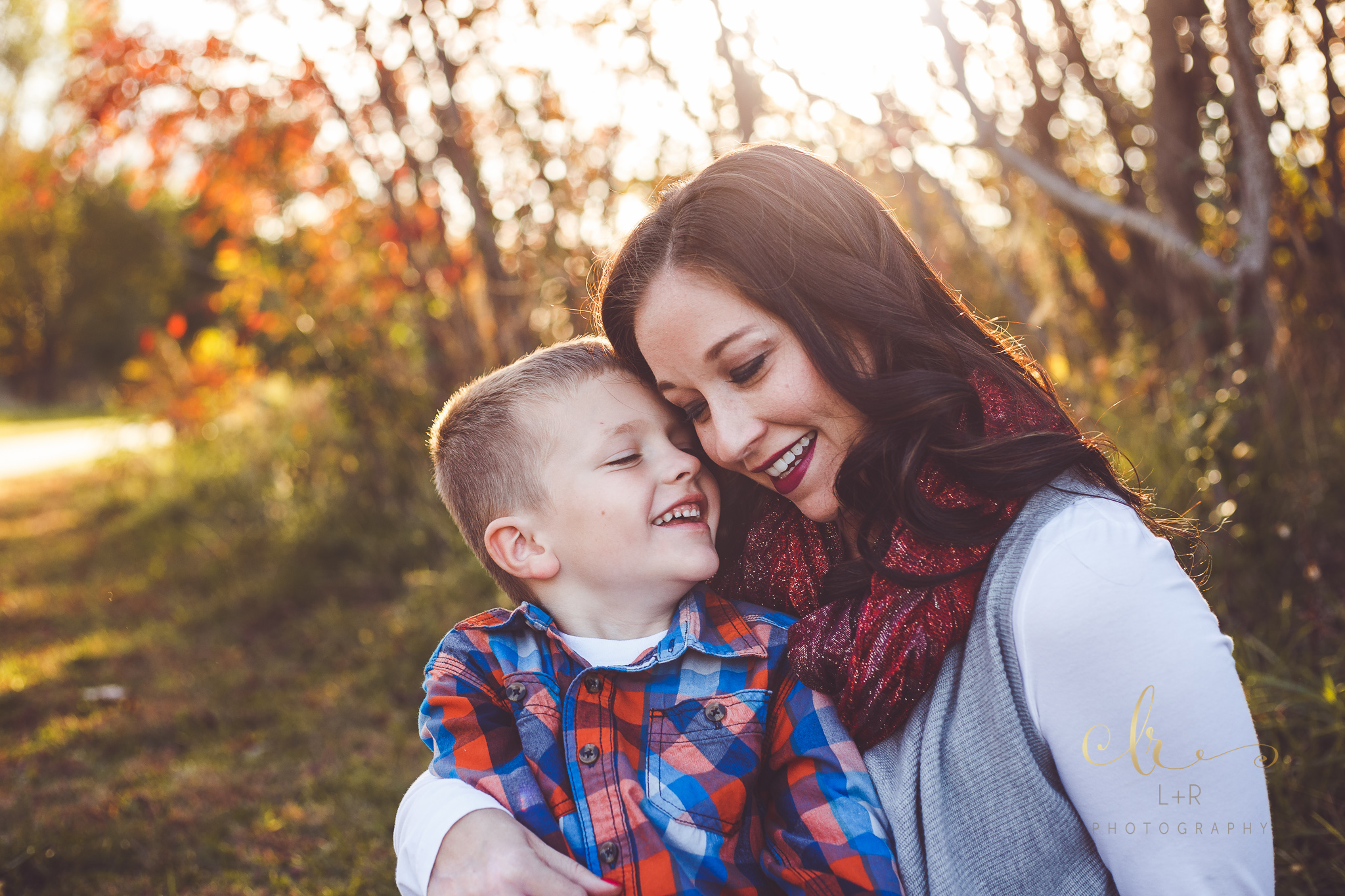 A photograph of a young mother sharing a special moment with one of her young sons, resting their foreheads against each other.  Photo credit - L&R Photography from Tulsa, Oklahoma