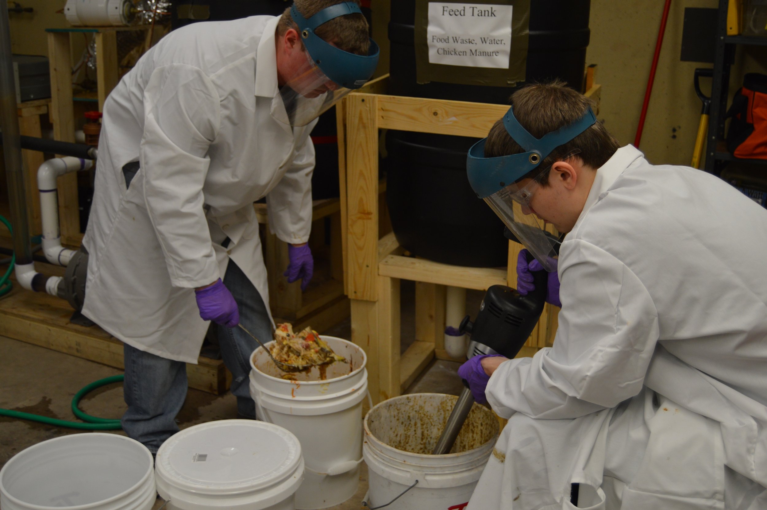The Biogas team preparing a slurry for their plant