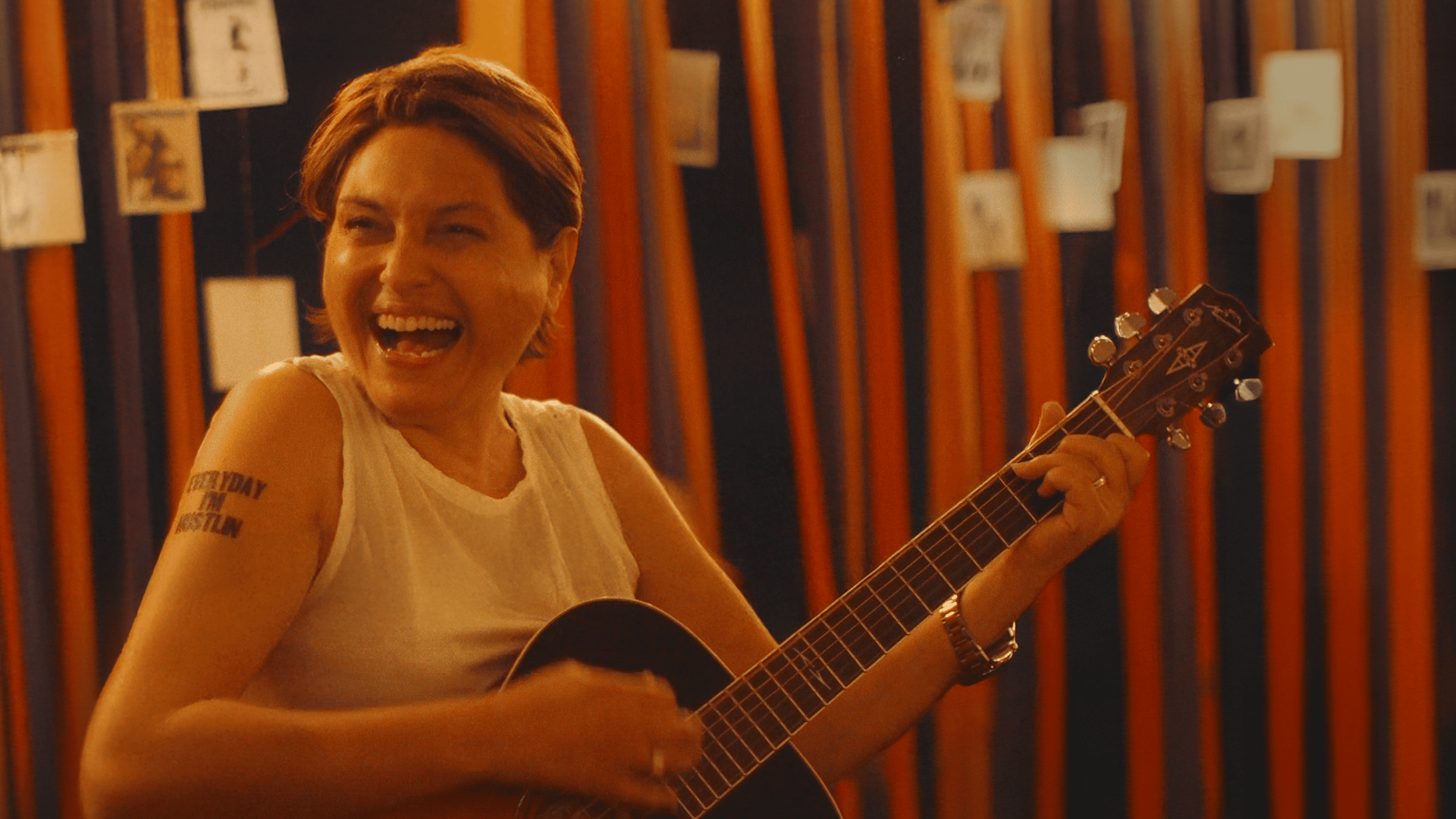 Rayya Elias laughing while playing a guitar