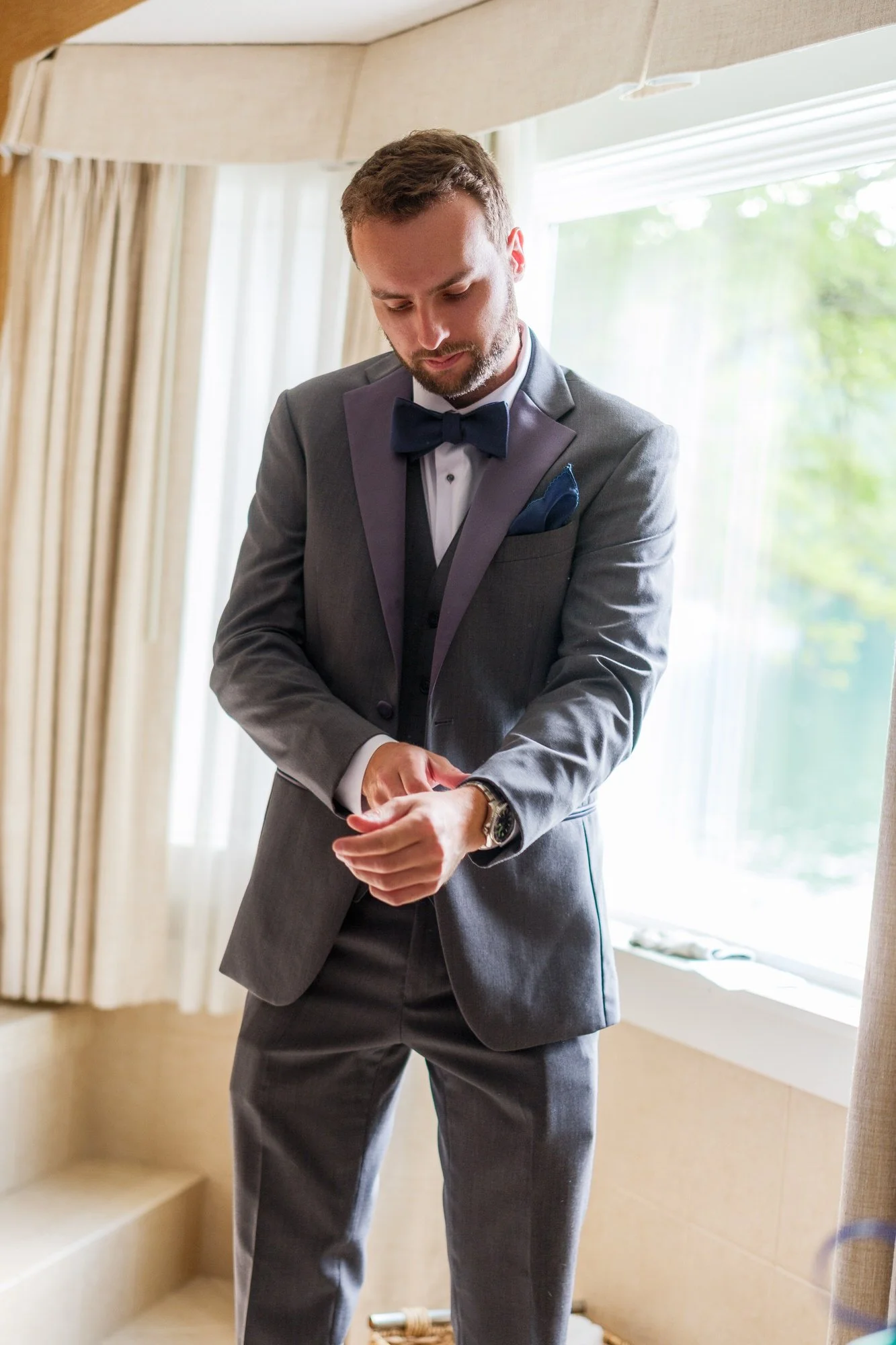 Groom adjusts his cuff before a Lake Morey Resort wedding in Vermont