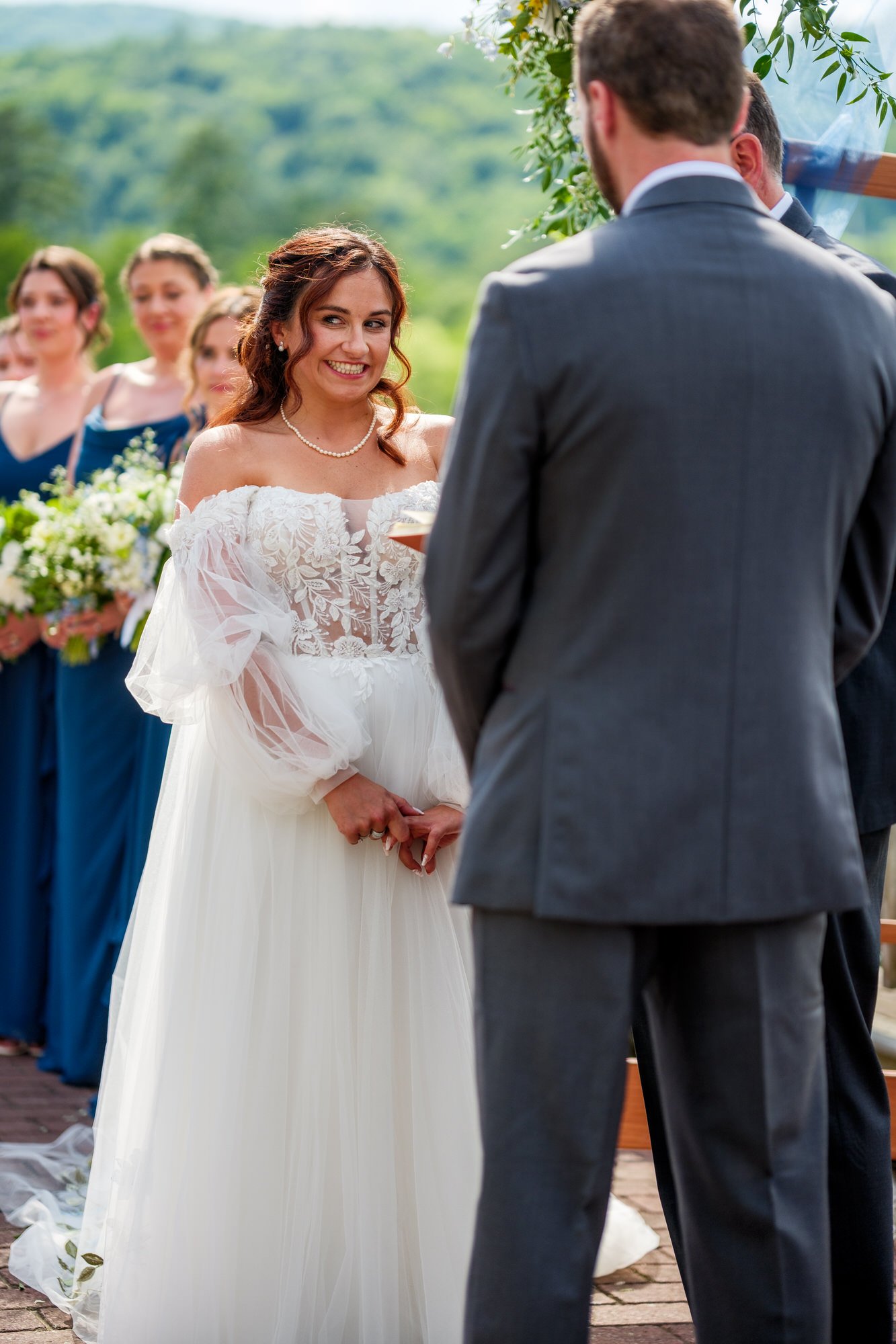 Bride smiles at groom during outdoor ceremony at Lake Morey Resort in Vermont