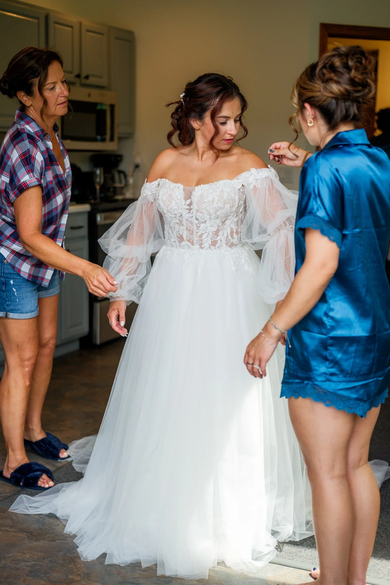 Wedding party helps the bride into her gown before a Lake Morey Resort wedding in Vermont
