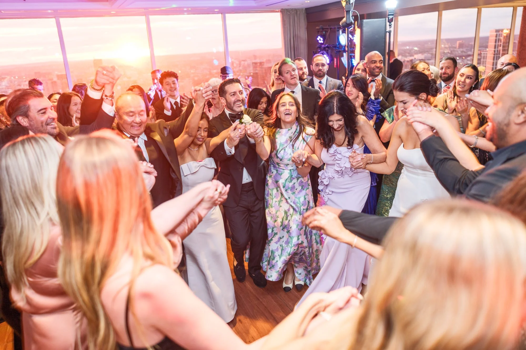 Groom leading guests in a jubilant circle dance at the UMass Club Boston Jewish wedding reception