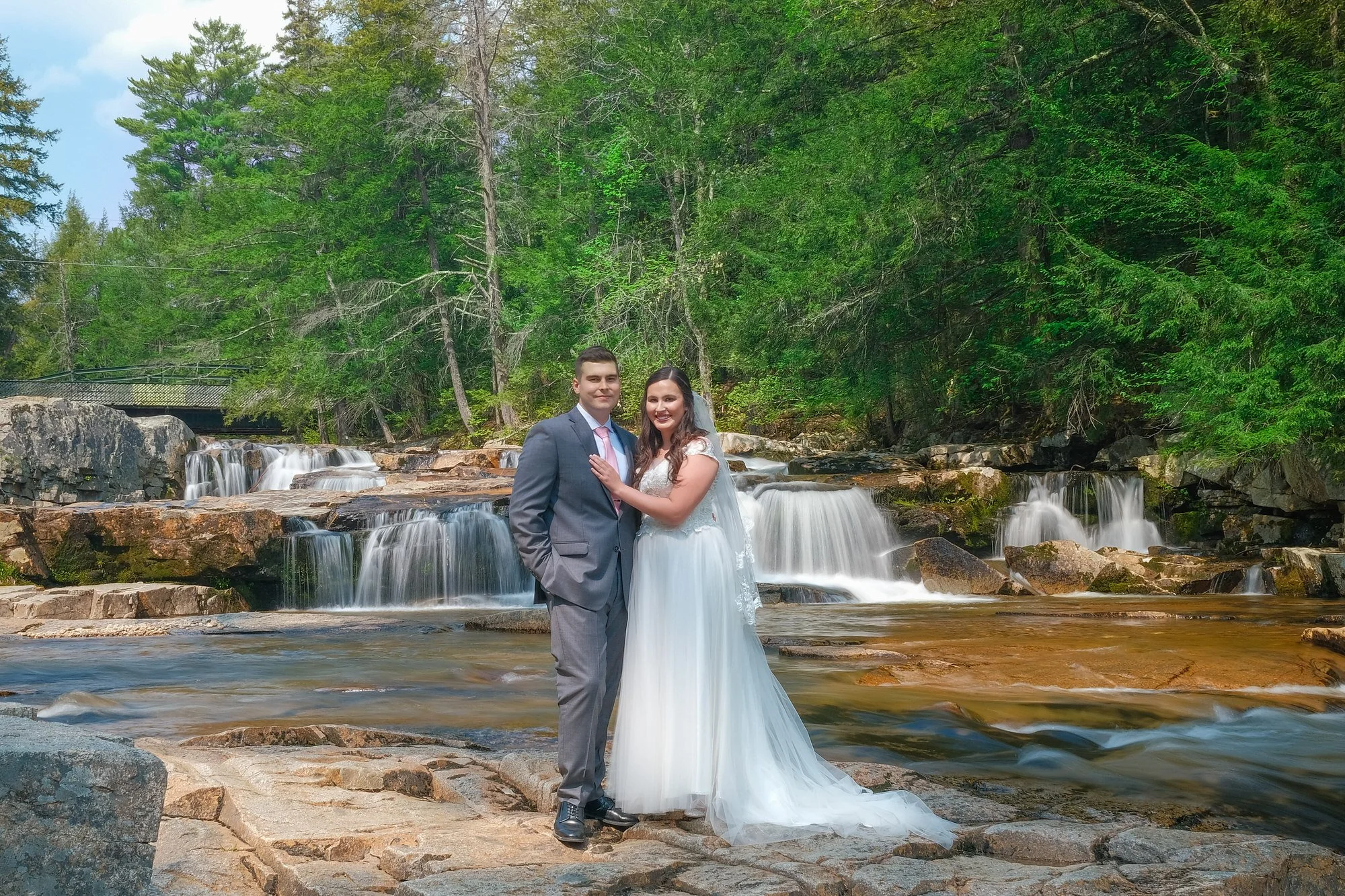Couple posing together in front of Jackson Falls in Jackson, NH during their White Mountains elopement at the Christmas Farm Inn