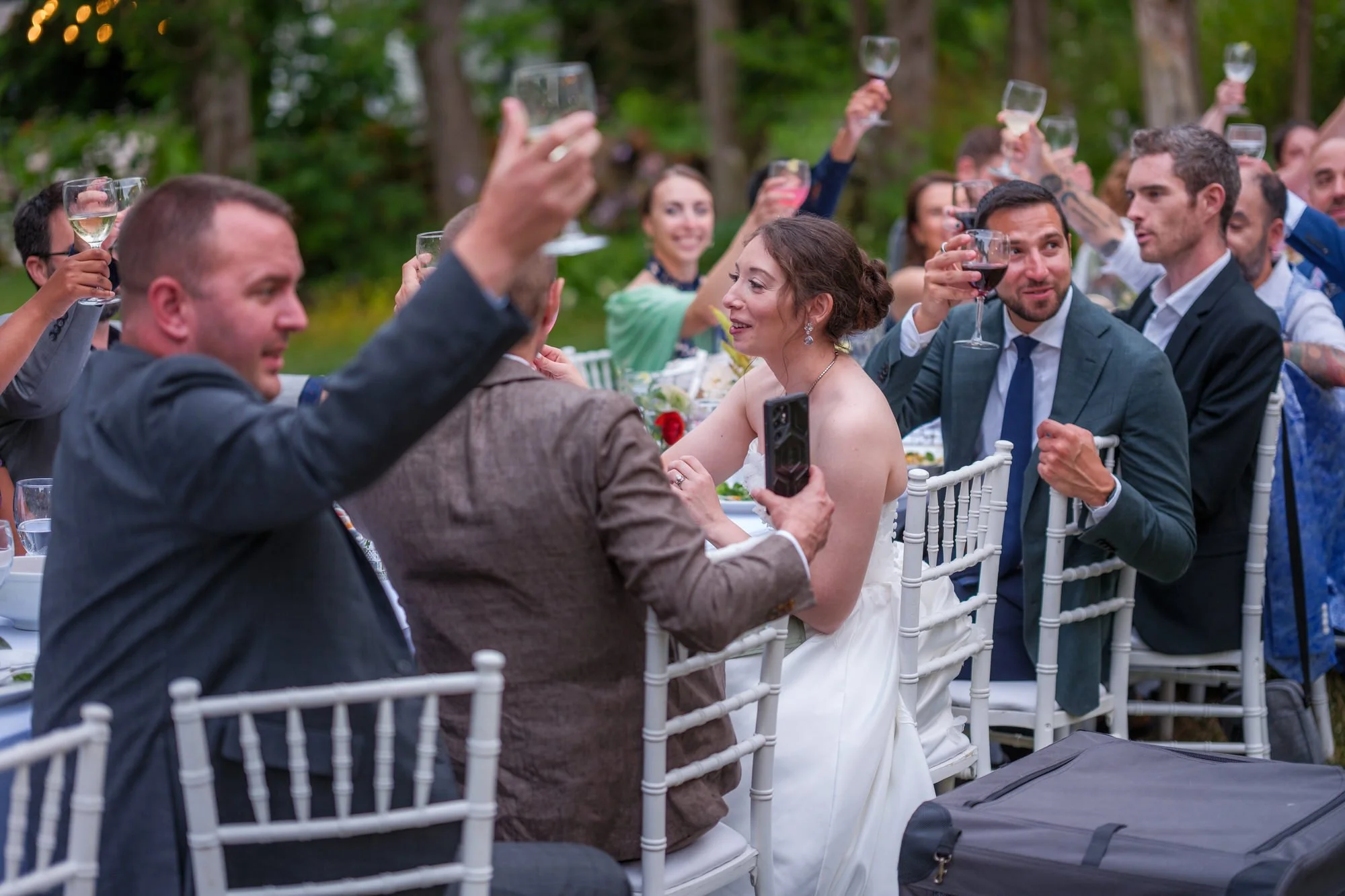 Guest raising a glass during a wedding reception toast