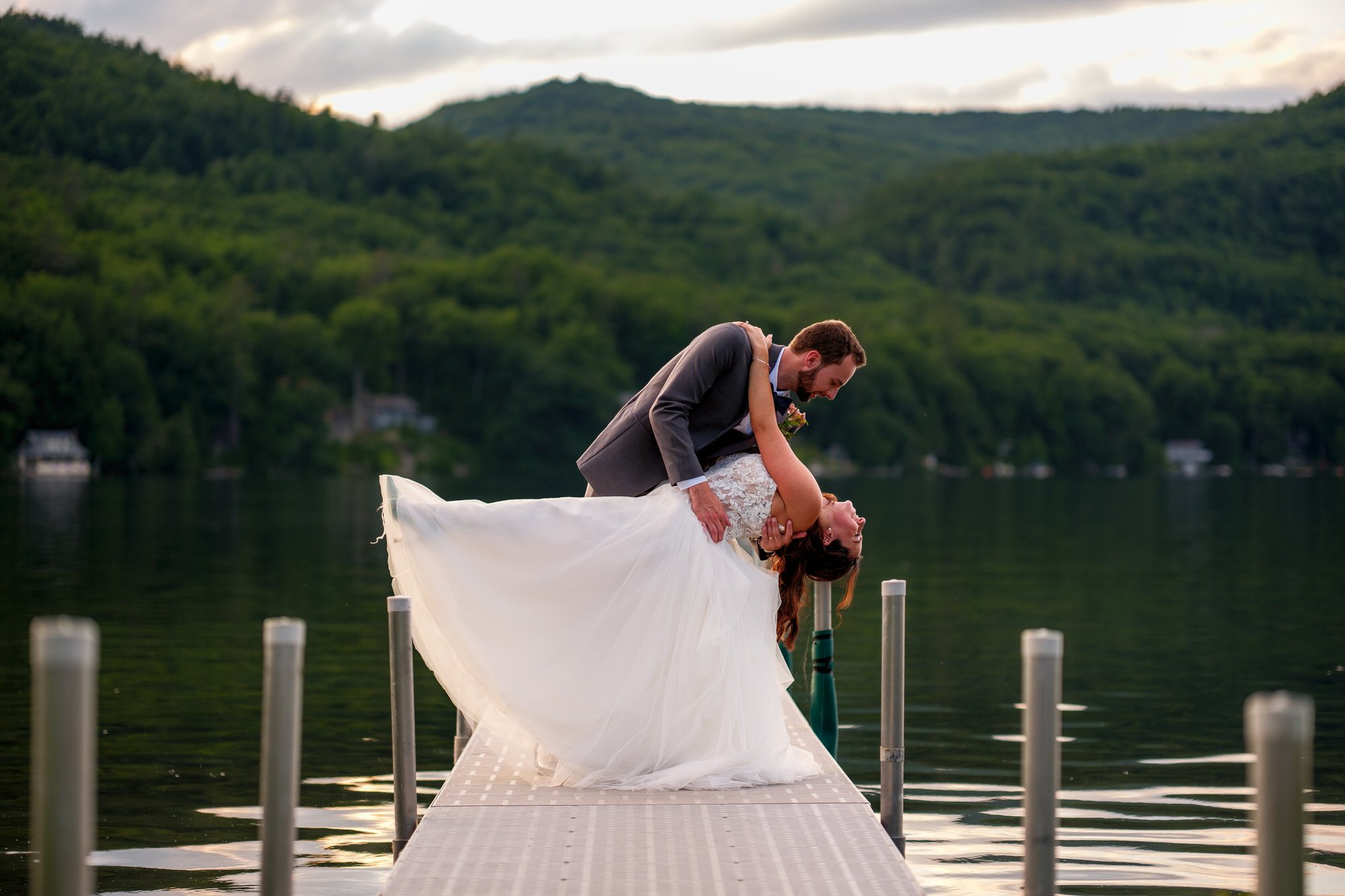 Groom dips bride on the dock during sunset portraits at Lake Morey Resort