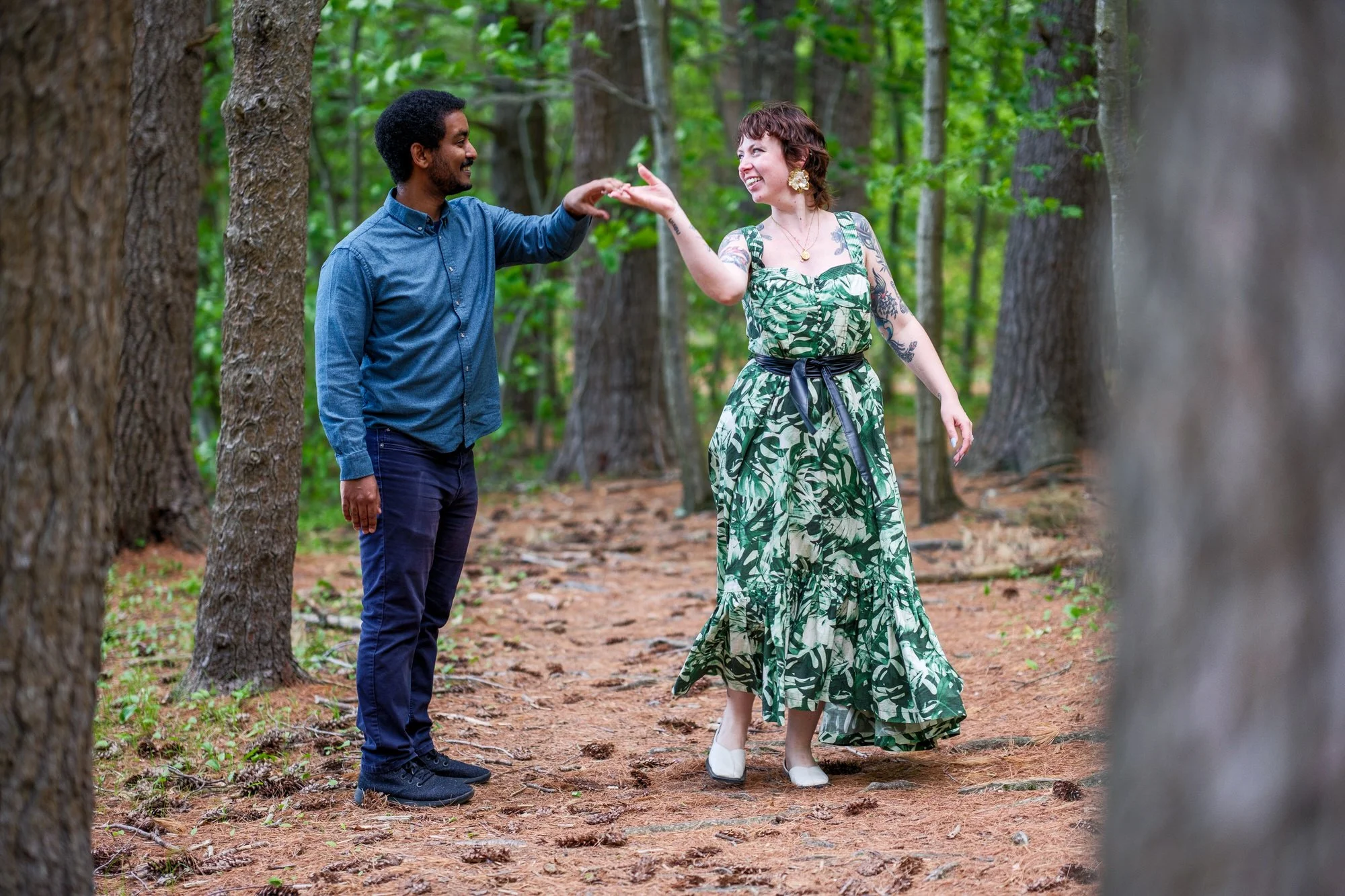 Newly engaged couple dancing among the trees at Middlesex Fells Reservation