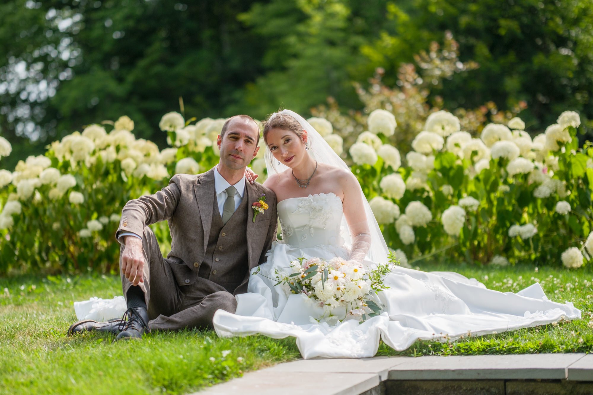 Bride and groom sitting together in the hydrangea garden