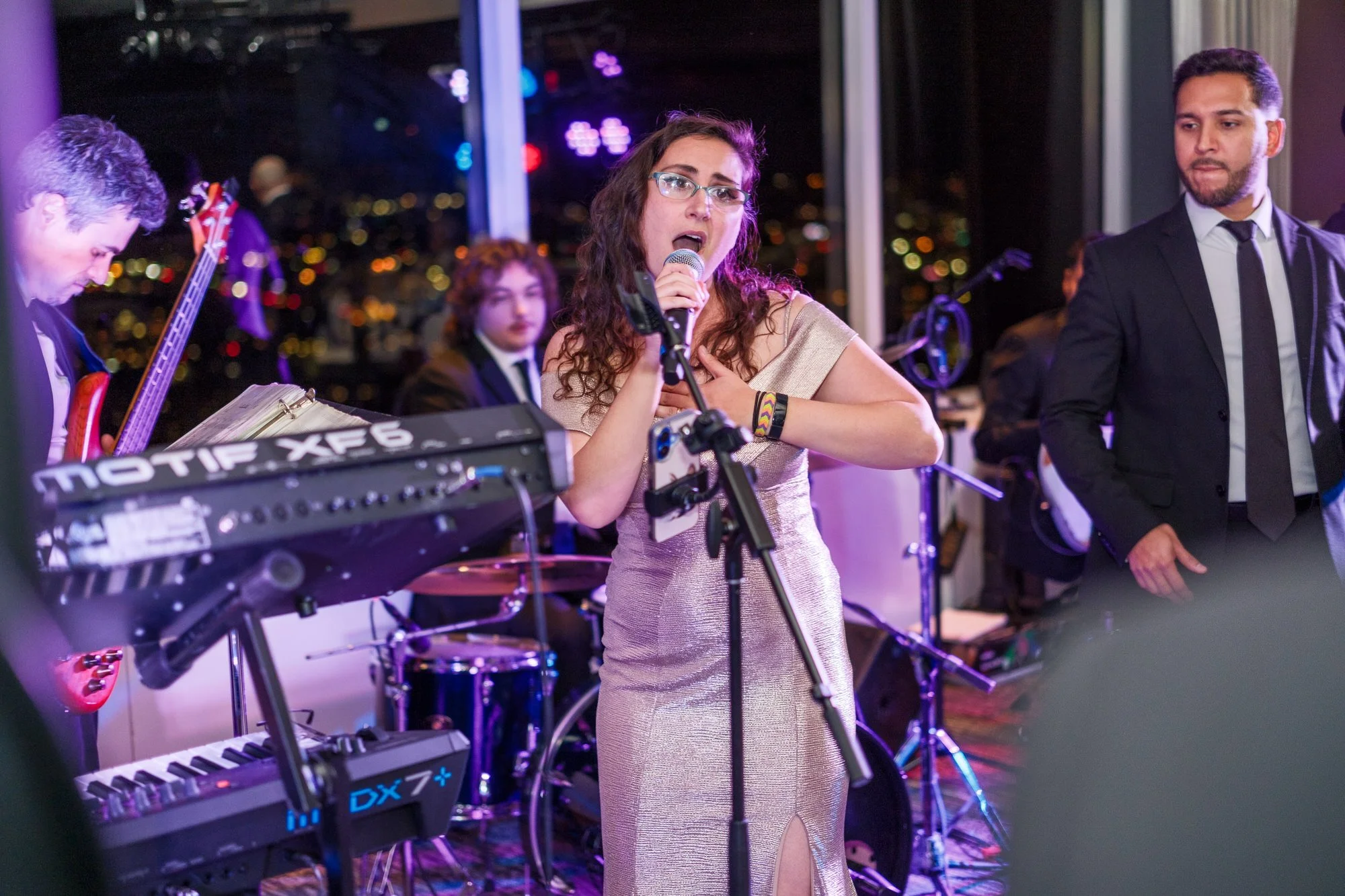Female vocalist performing passionately with the live wedding band at the UMass Club Boston reception