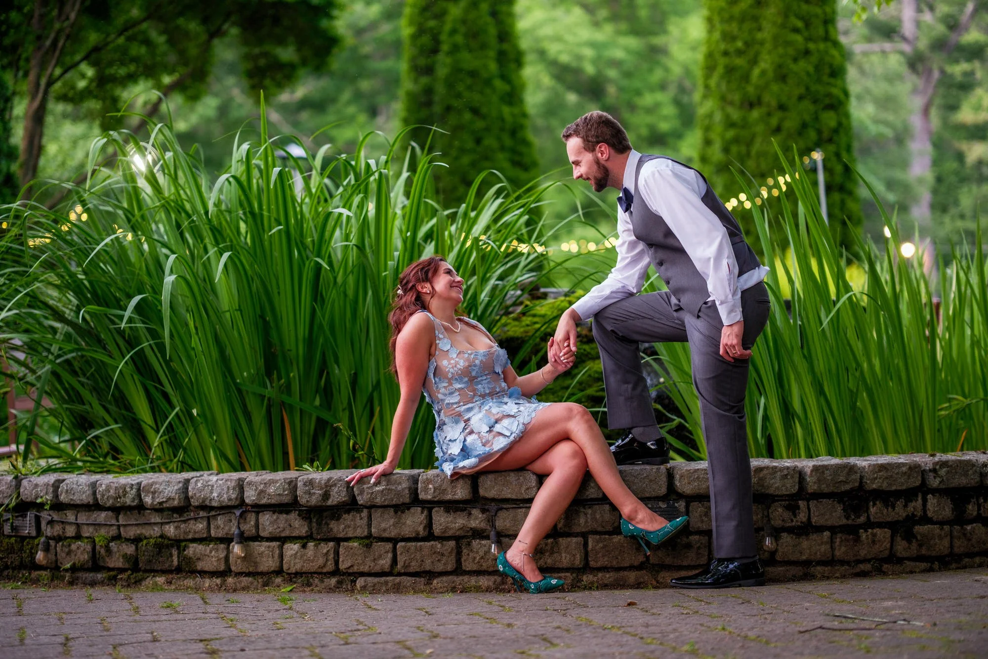 Bride and groom pose by garden wall at Lake Morey Resort wedding venue