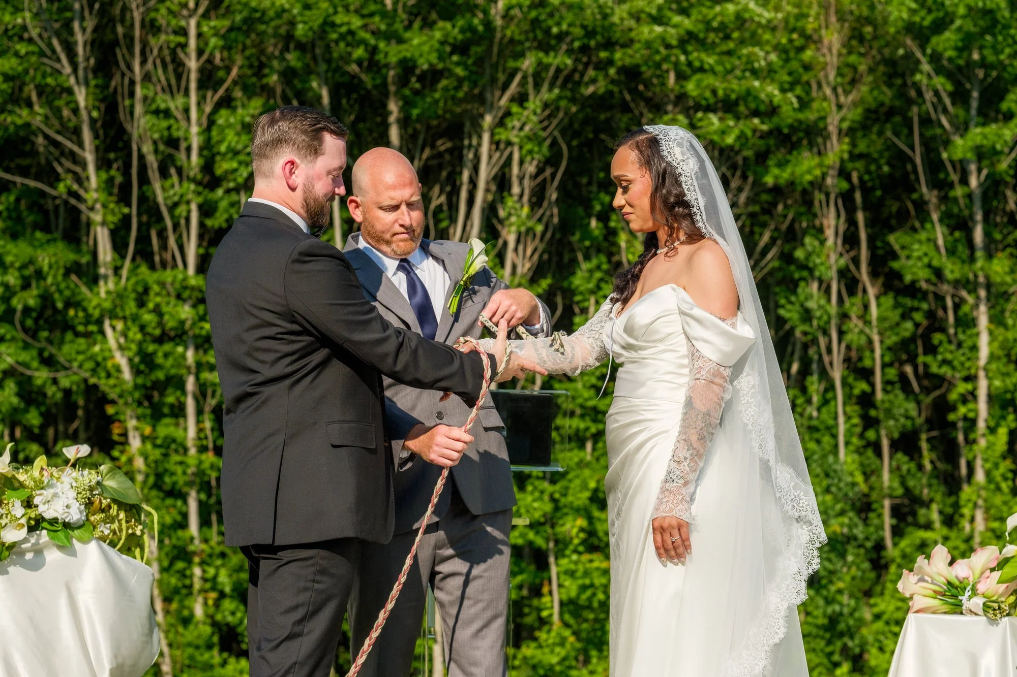 Ring exchange and knot ceremony during outdoor Hyla Brook Estate wedding